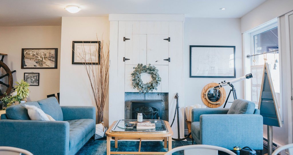 Cozy photo of the office interior with a couple of soft blue couches and a fireplace