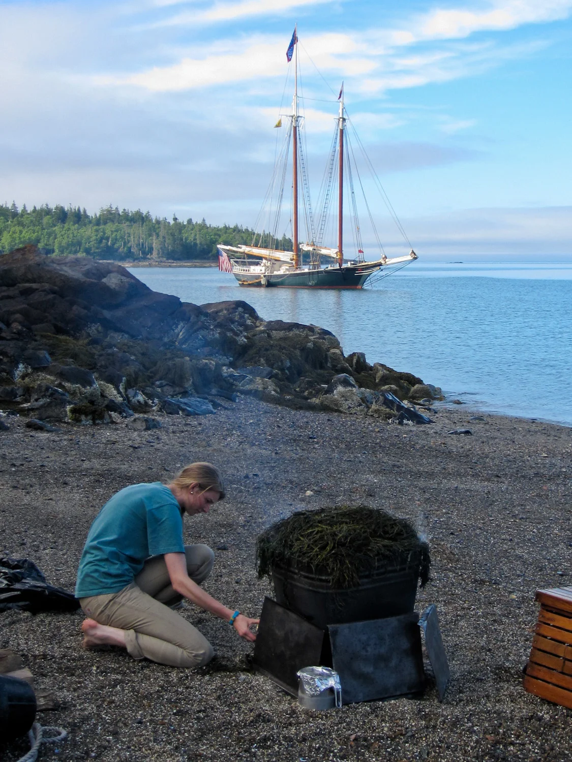 Keeping the fire stoked under the lobsters and corn on the cob as the Taber sits anchored off shore.