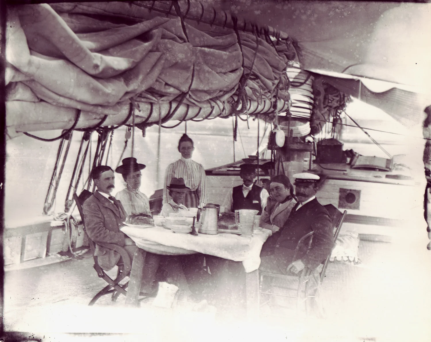 A well-to-do family enjoying a summer aboard the Taber, sailing the waters between Long Island and Newport, circa 1901.