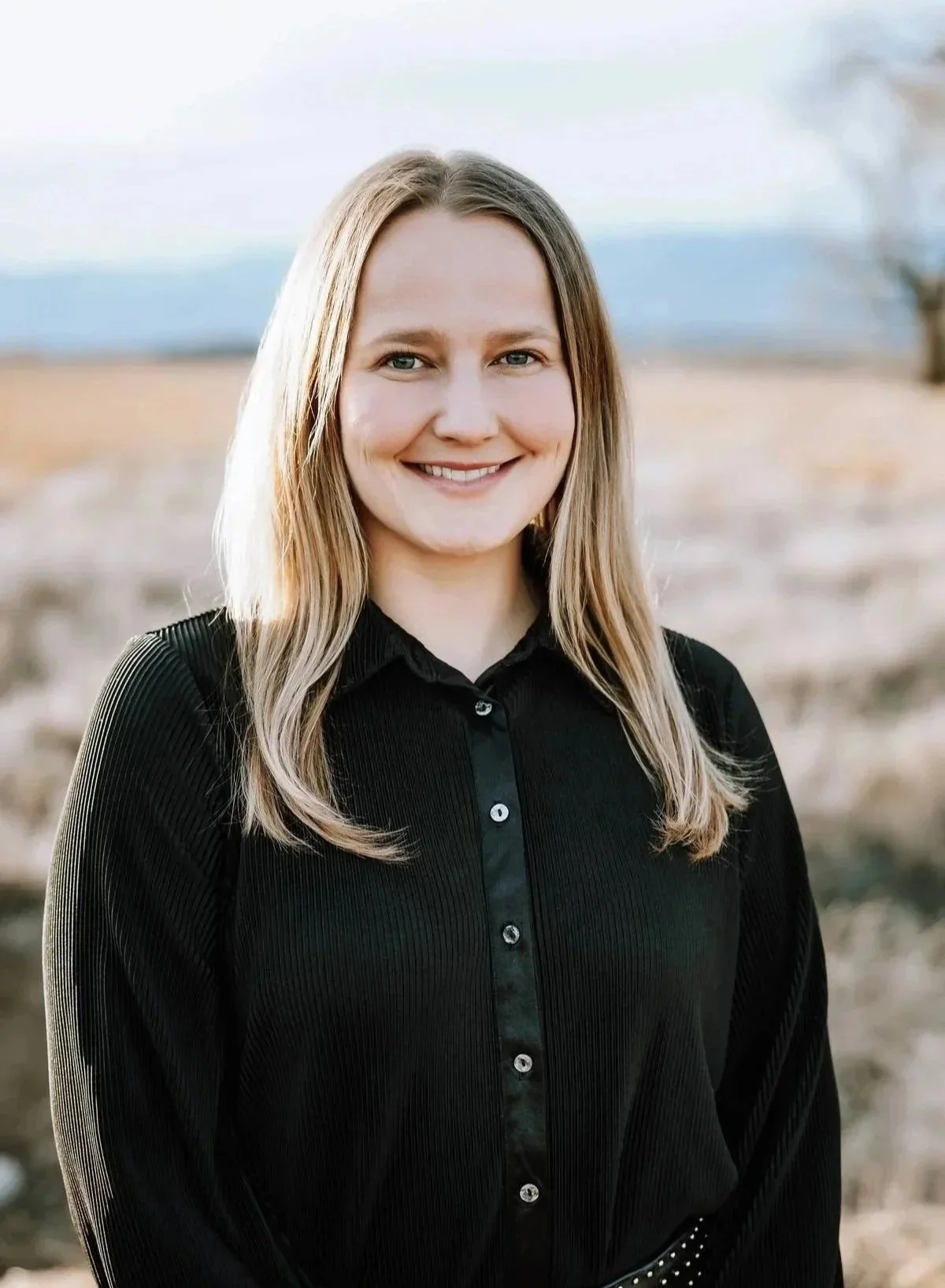 Person smiling on a beach with ocean background