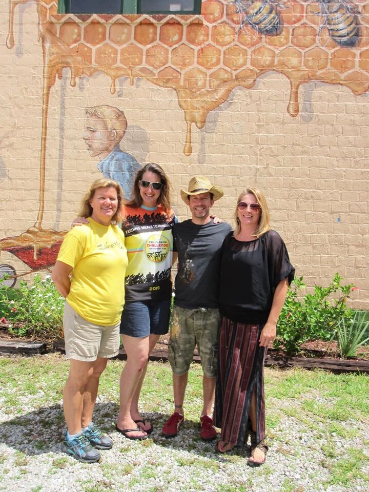 A group of people standing together in front of the completed mural