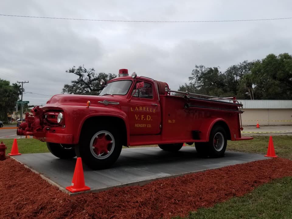 Old Betsy Fire Truck parked on a concrete display with four cones on each corner around it