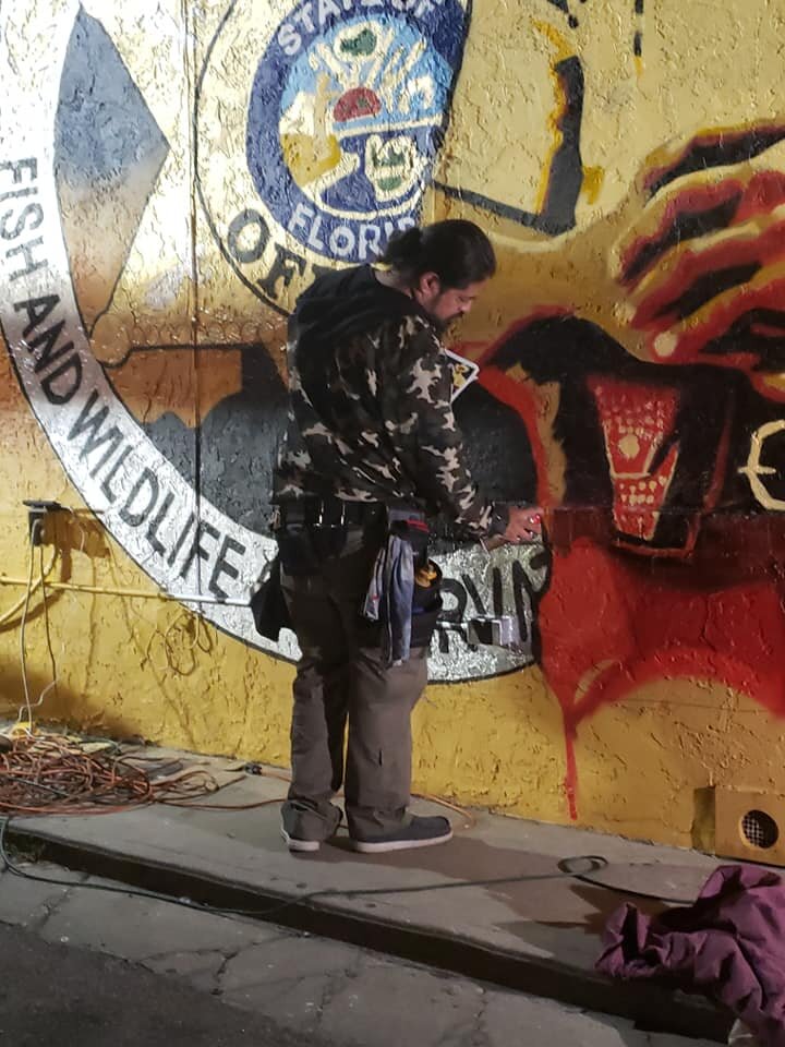 Artist working on the mural