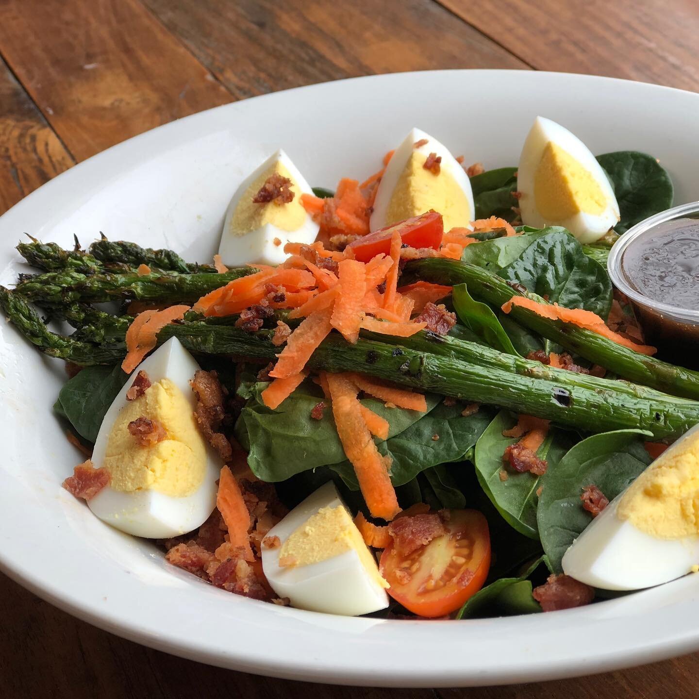 Spring has such unpredictable weather! Warm &amp; sunny 🌞 or cold &amp; cloudy ⛅️? No worries, we offer foods for any moods 😎. Check out our salad special today 🥗: baby spinach topped with grilled asparagus, carrots, grape tomatoes, applewood smok