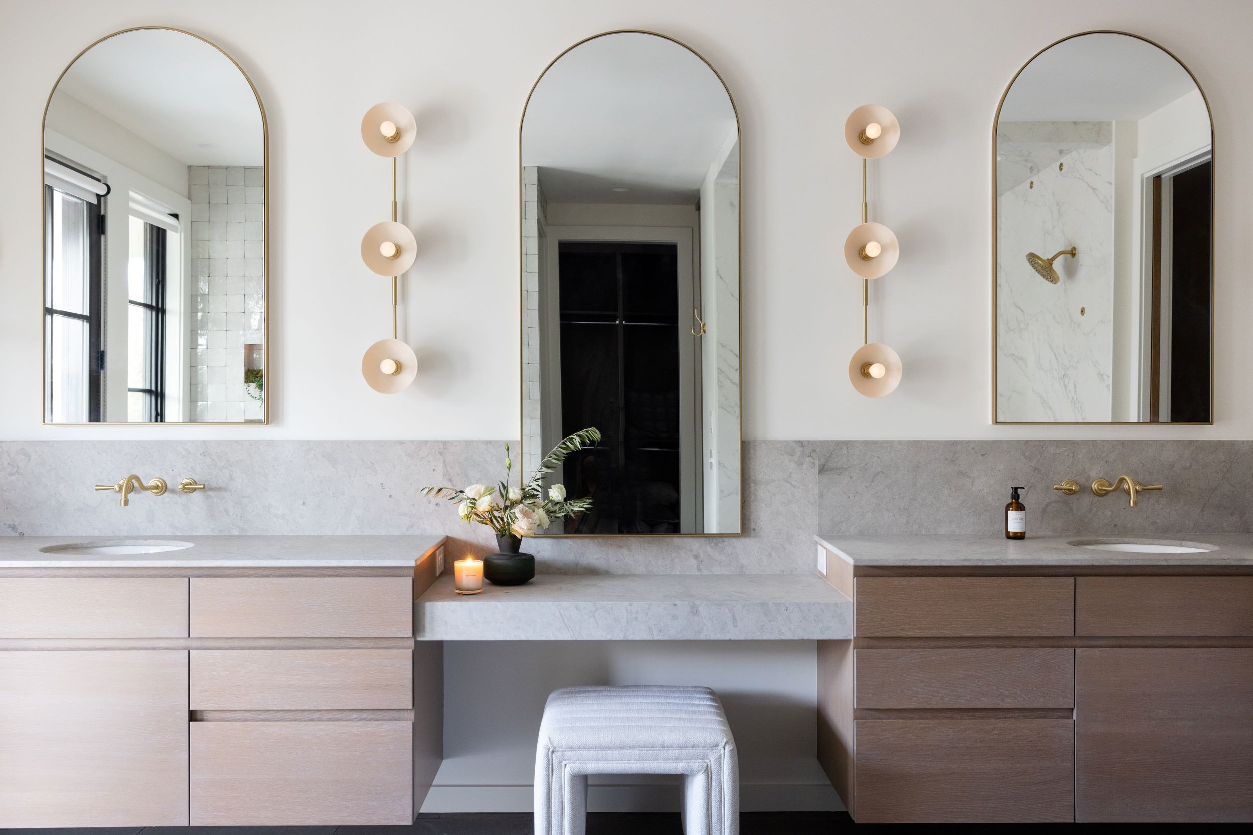 dream bathroom vanity with arched brass mirrors