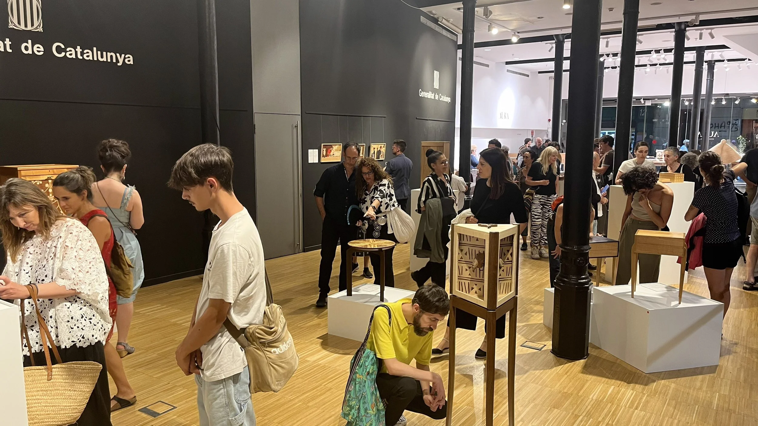 Visitantes observan las piezas durante la inauguración de El lenguaje de la madera.