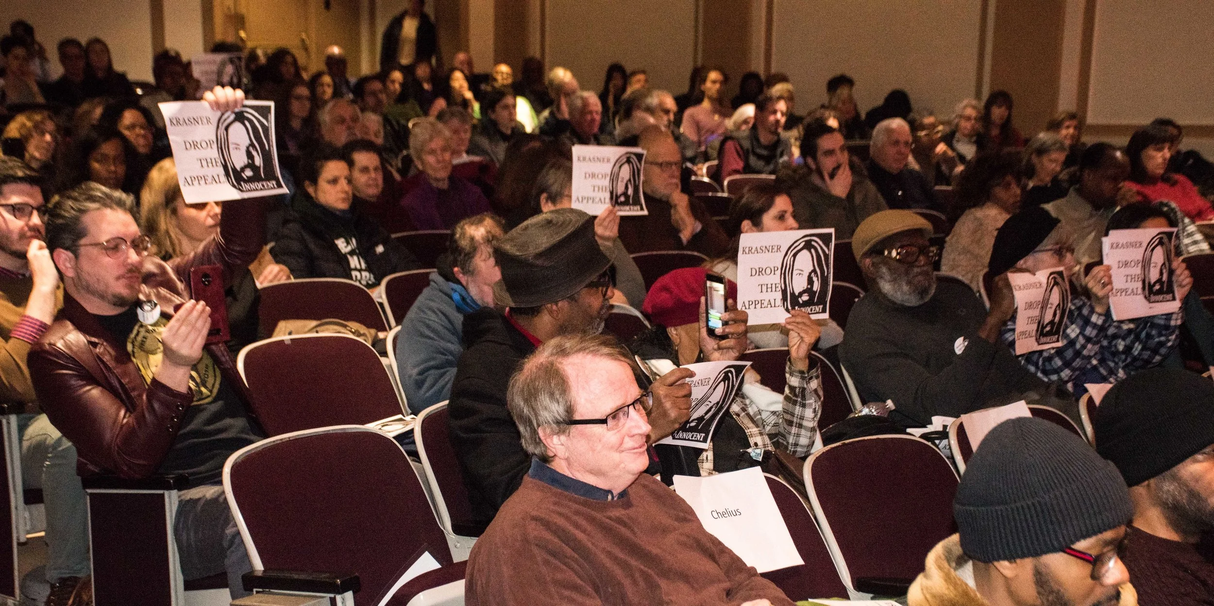 2.11.19 Philadelphia - Mumia supporters hold up “Krasner, Drop the Appeal” posters as the phila. DA Larry Krasner speaks at a Criminal Justice Reform Panel at the Philadelphia Main Library.