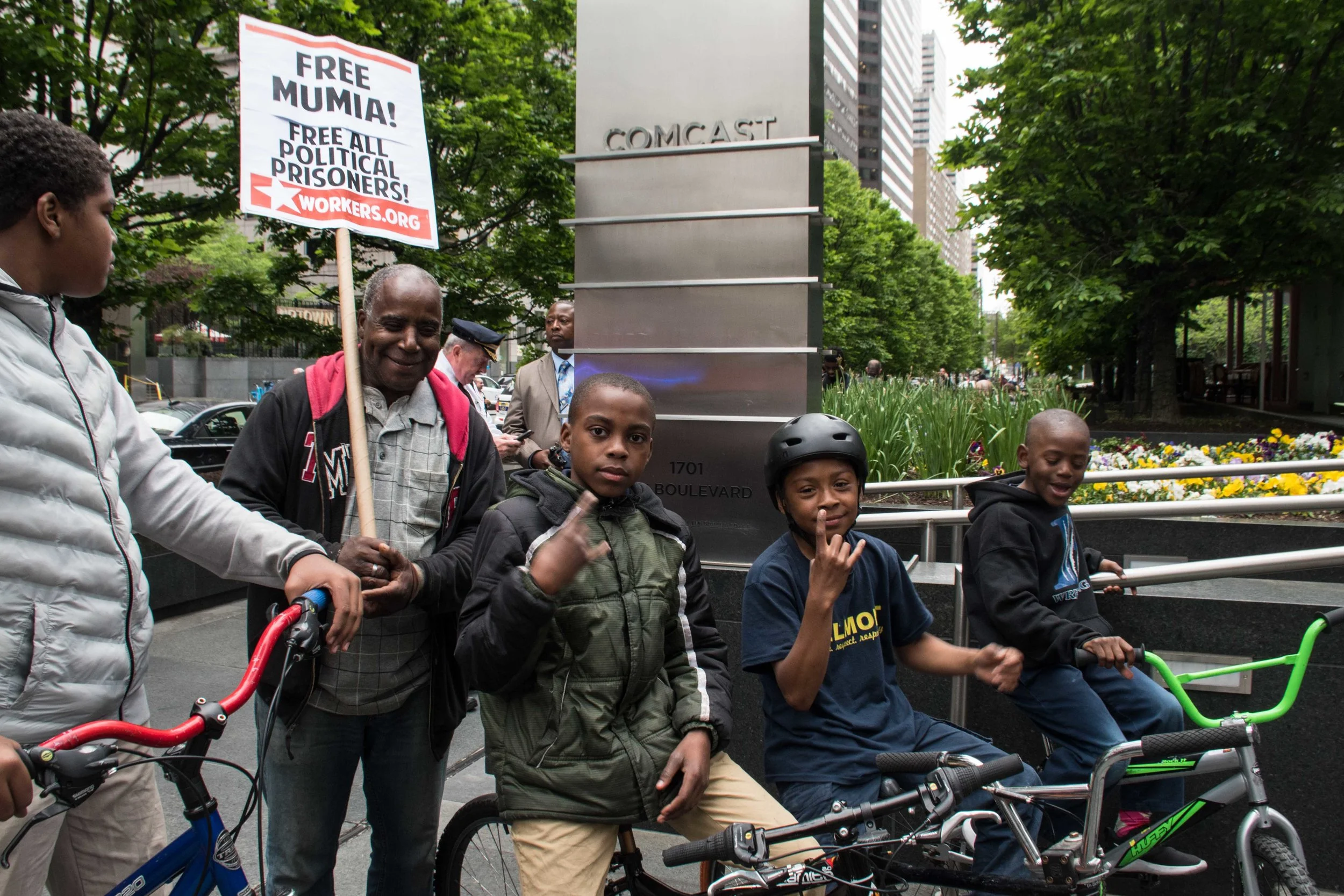 Young bikers express their solidarity as May 1st International Workers Day marchers stop at Comcast to protest against their anti-Immigrant policies. Photo credit: Joe Piette