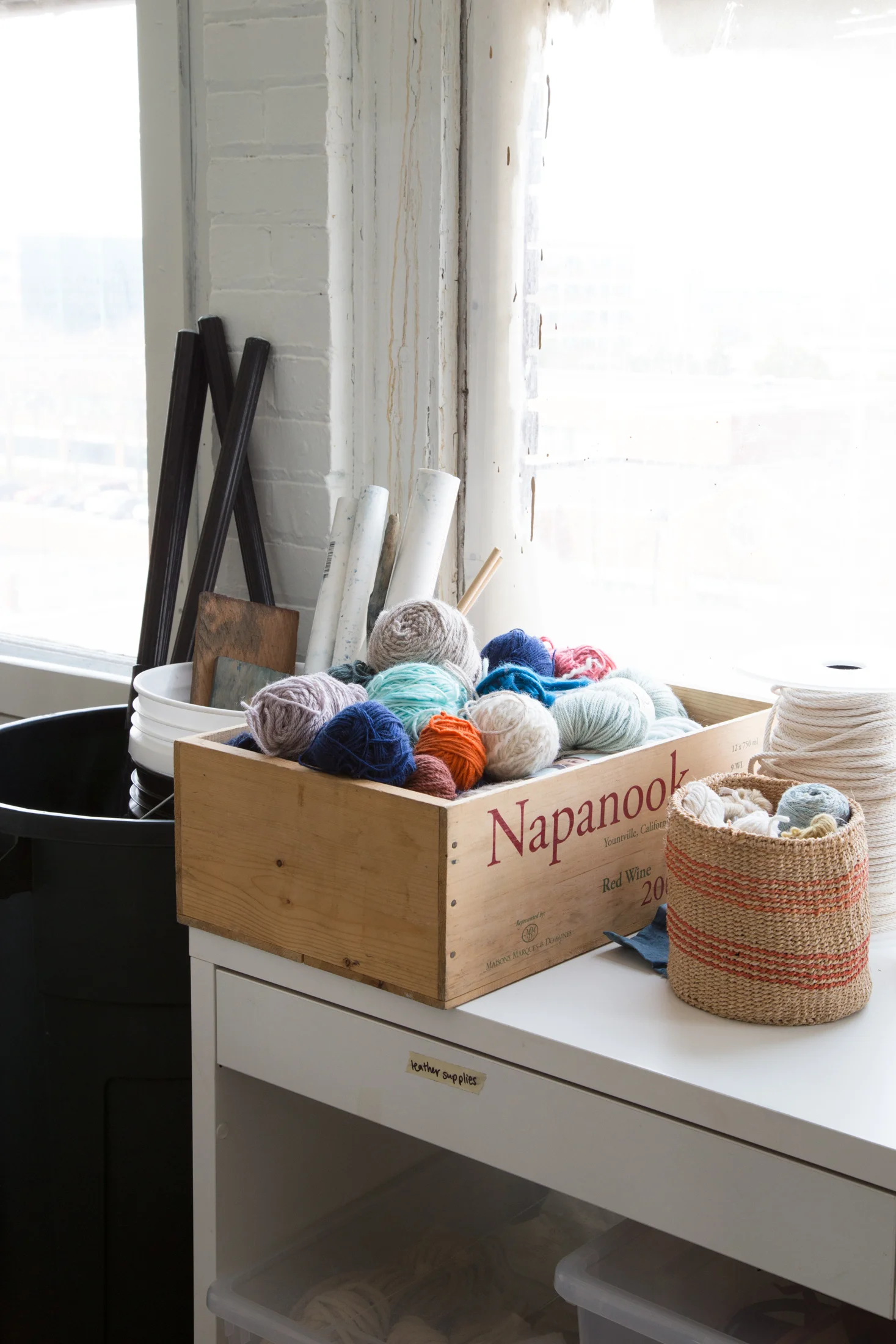 a small selection of my yarn stash and a cone of cotton rope. Handwoven basket gifted to me from a friend who worked with an organization called Seeds to Sew in Kenya. Buckets and shibori tools for creating different effects on indigo dyed pieces 