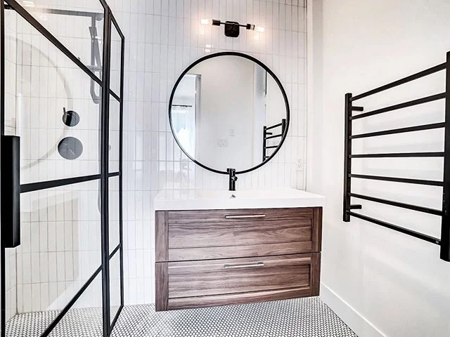 There wasn&rsquo;t much space to add a second bathroom to the suite, so we made the most of what we had to work with. White finishes, black accents, and a touch of wood helped brighten up this little space! #weloveblackaccents #bathroomdesign
