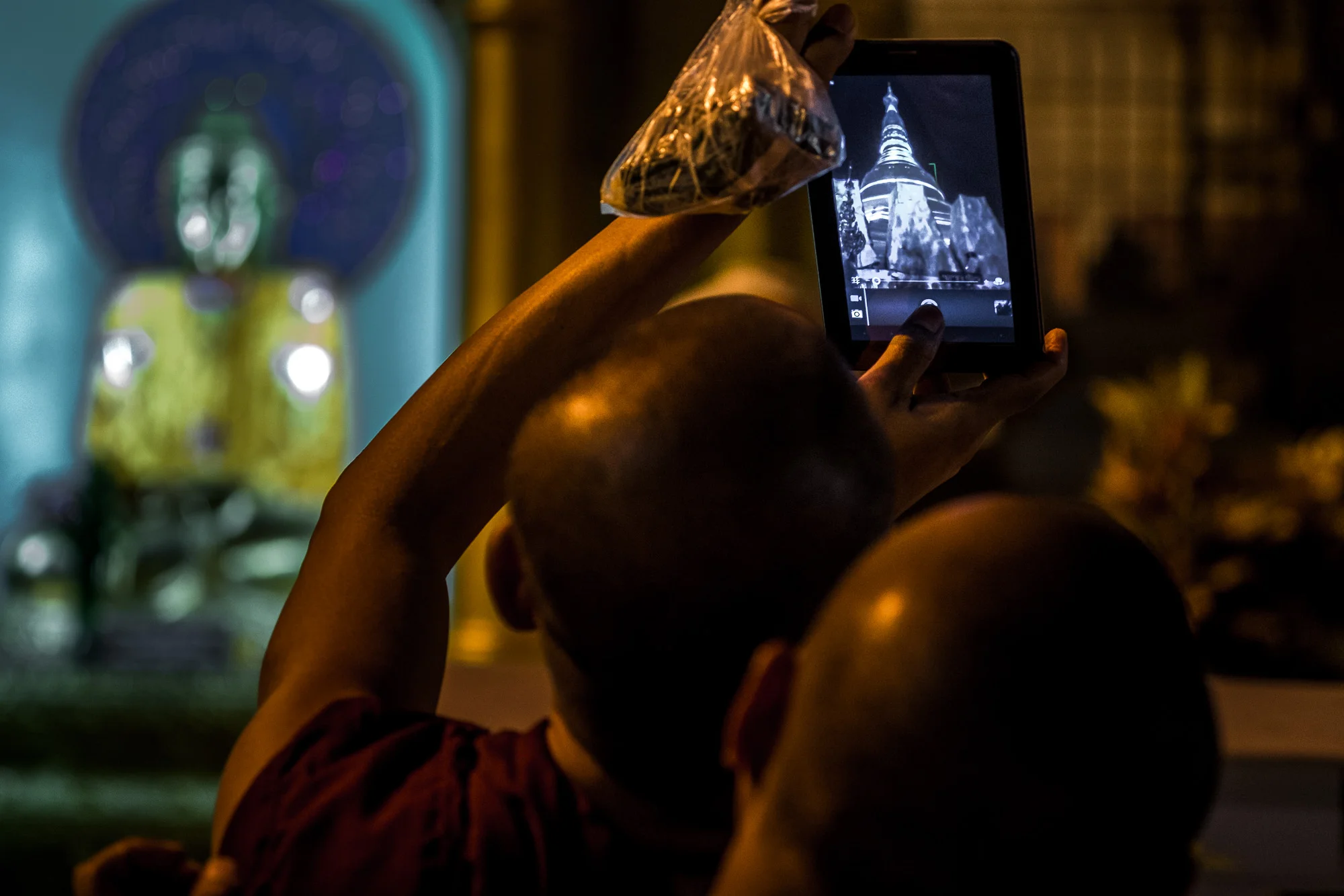  Young monk taking picture with his iPad of Shwedagon Pagoda, the most sacred Buddhist pagoda in Myanmar and the largest gold pagoda in the world. Yangon,&nbsp;Myanmar. 