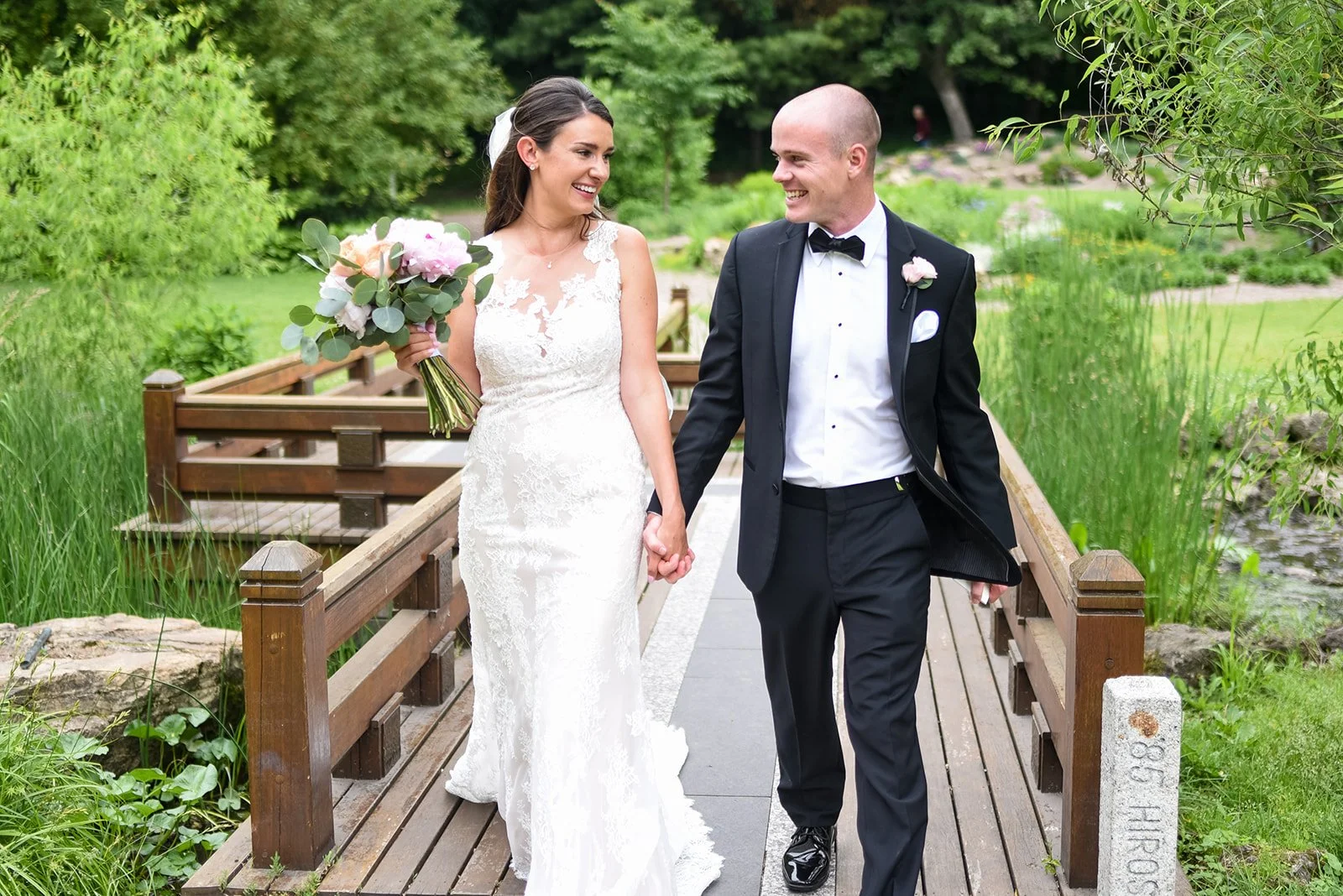 Beautiful outdoor setting with lots of greenery bride and groom look at each other with glee Twin Birch Studio