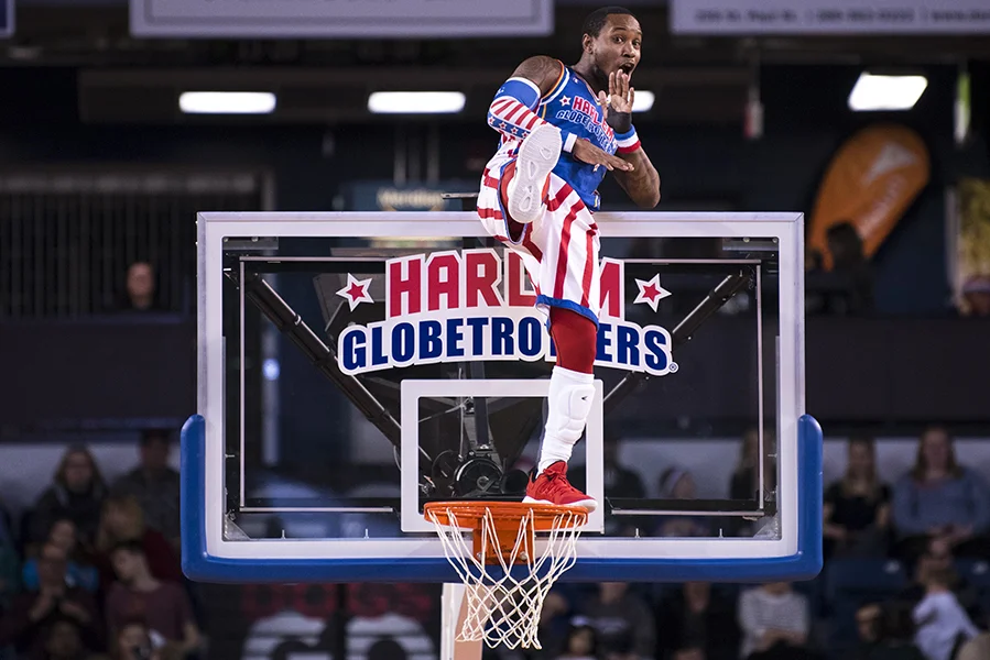 St. Catharines, ON - April 12: “Primetime” Maberry of the Harlem Globetrotters strikes a pose while standing on the rim of a basketball net during their April 12 game in St. Catharines, ON.