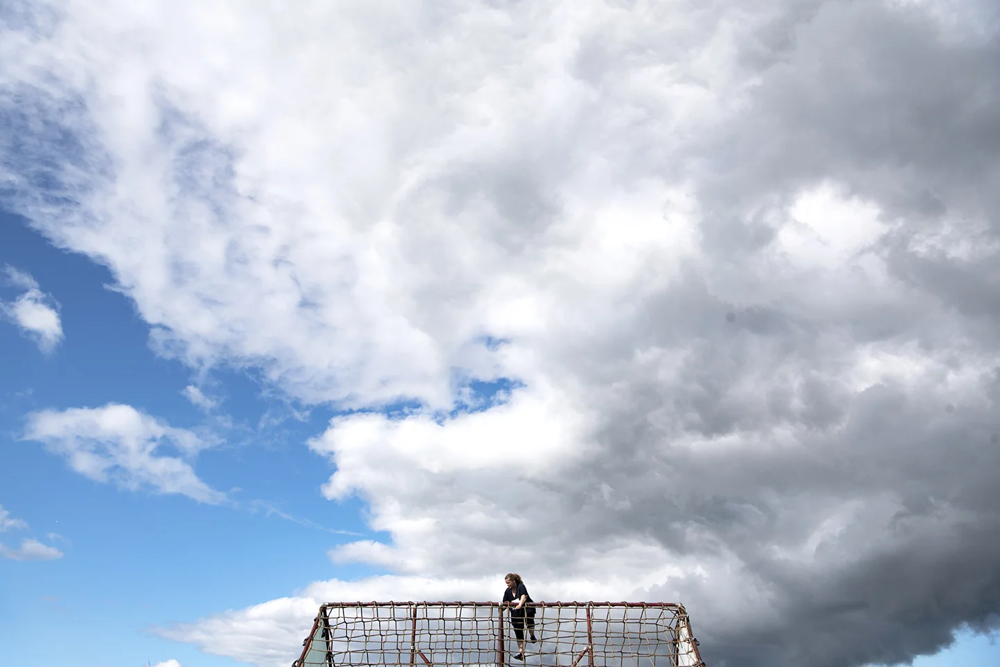 A participant in the 5K Foam Fest, an obstacle course-based fun run, climbs a rope-ladder obstacle called the “cargo climb.“