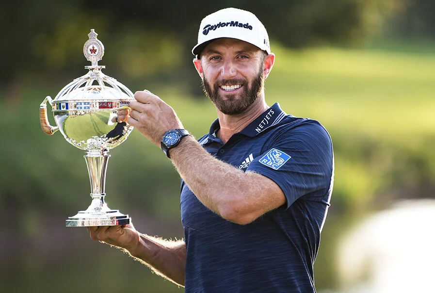 Dustin Johnson poses on the eighteenth green of Glen Abbey Golf Club after winning the RBC Canadian Open on July 29, 2018.
