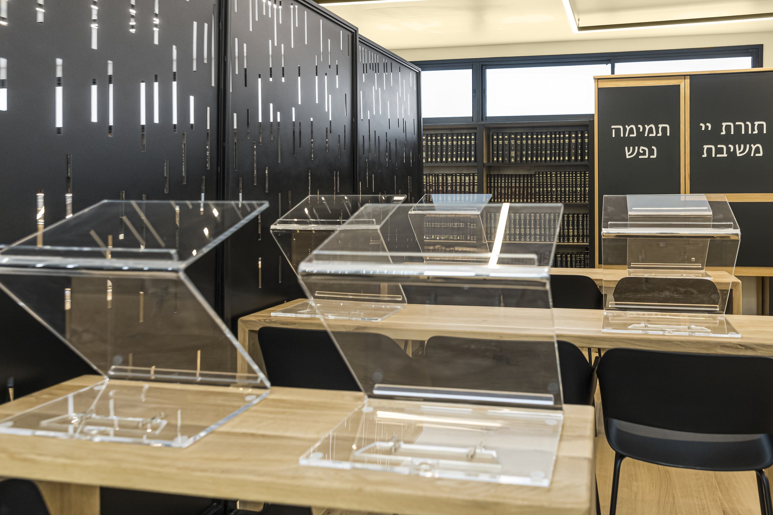  Enter a space where tradition meets modernity at the trendsetting Kollel in Raanana, adorned in sleek black and white aesthetics.     