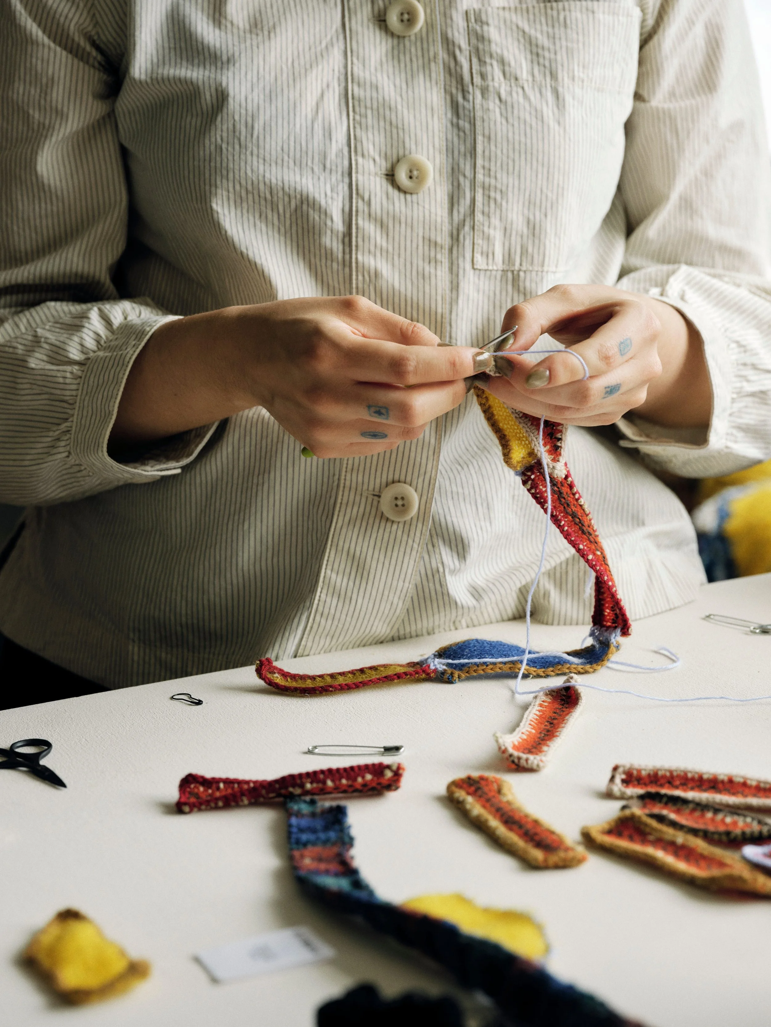 Hand sewing small pieces of knitted fabric