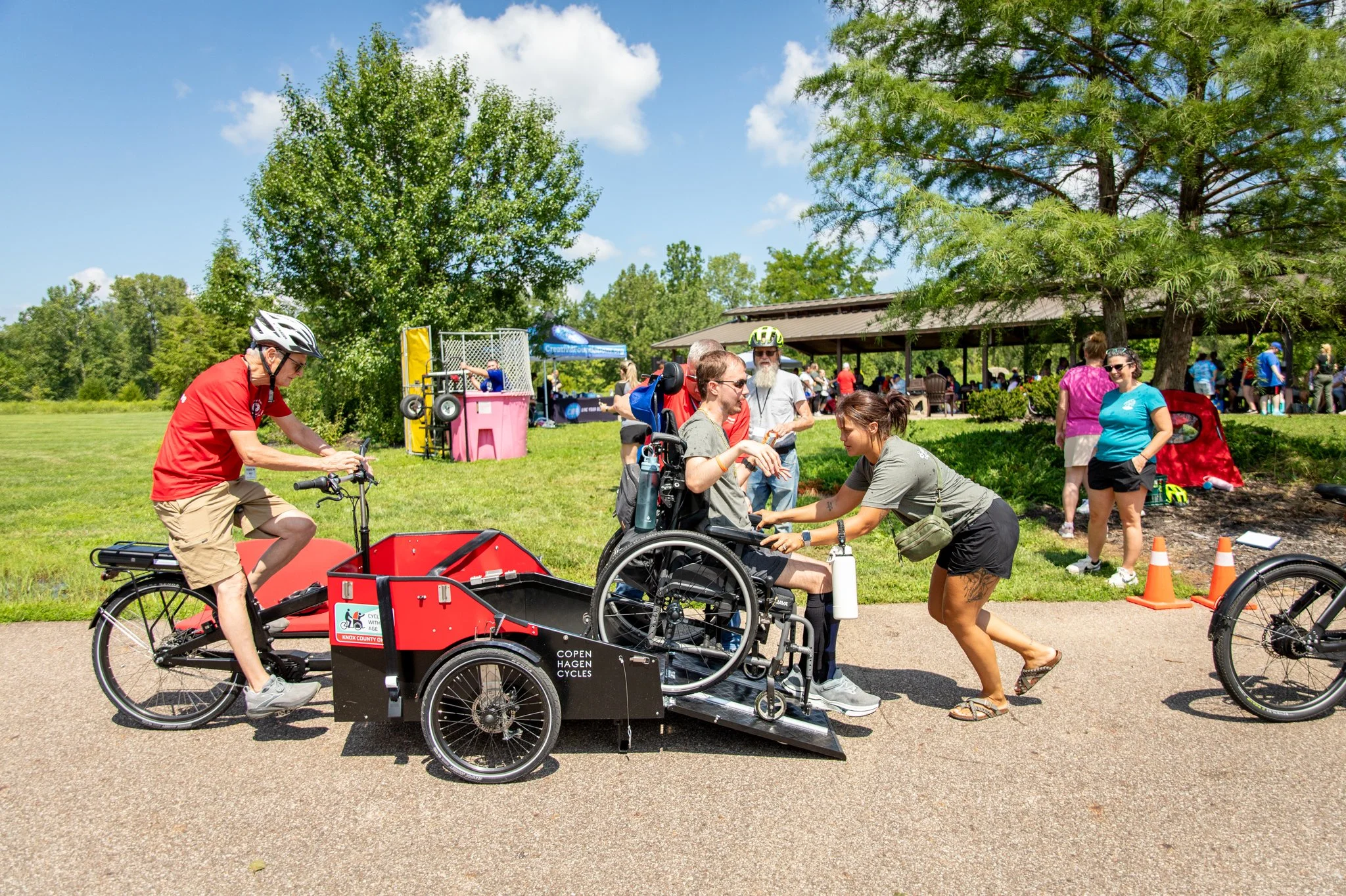 young man in wheelchair, preparing to ride on a happy spokes bike