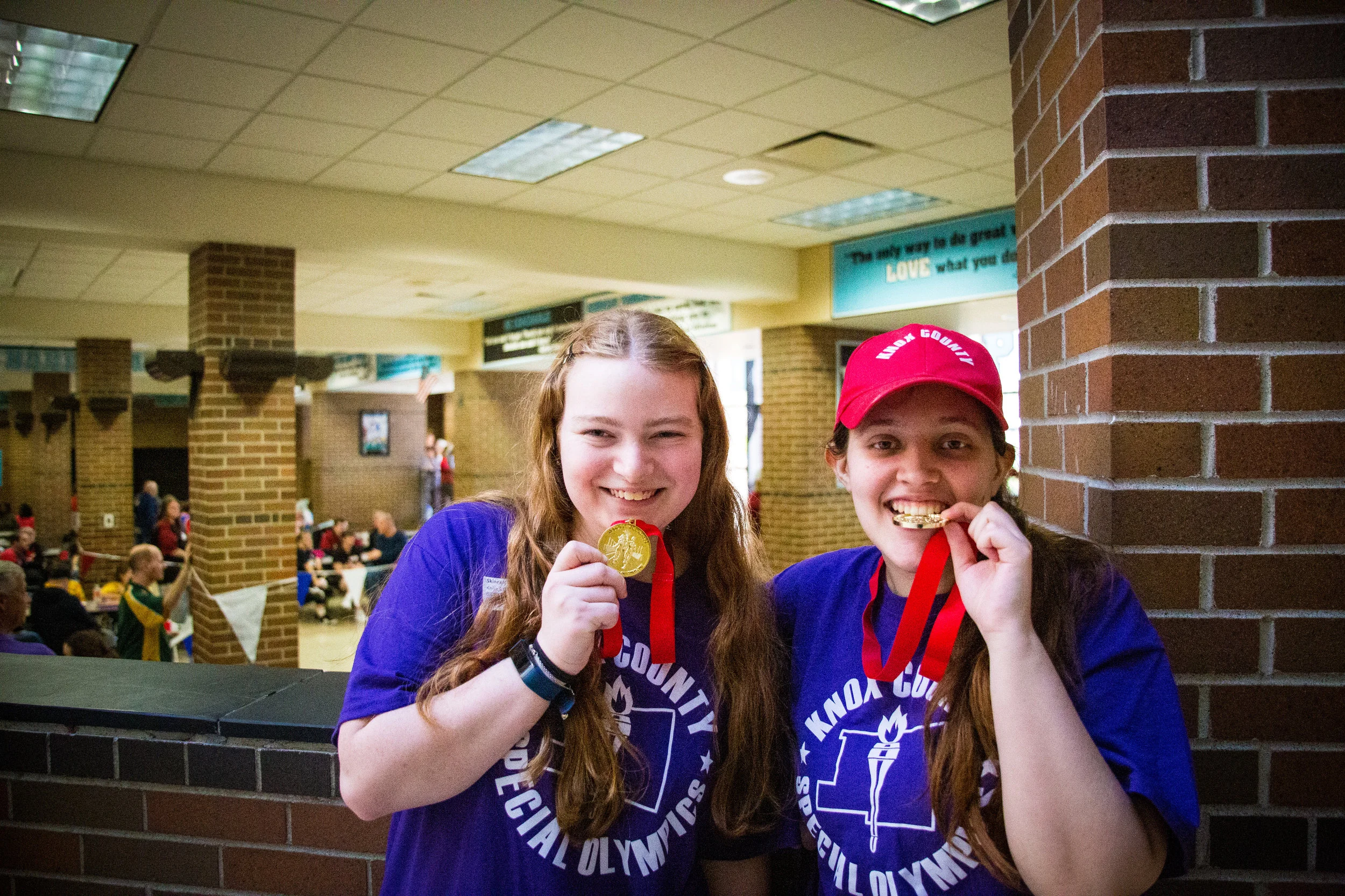 Portrait of two young women with disabilities posing with the medals they won at a Special Olympics competition