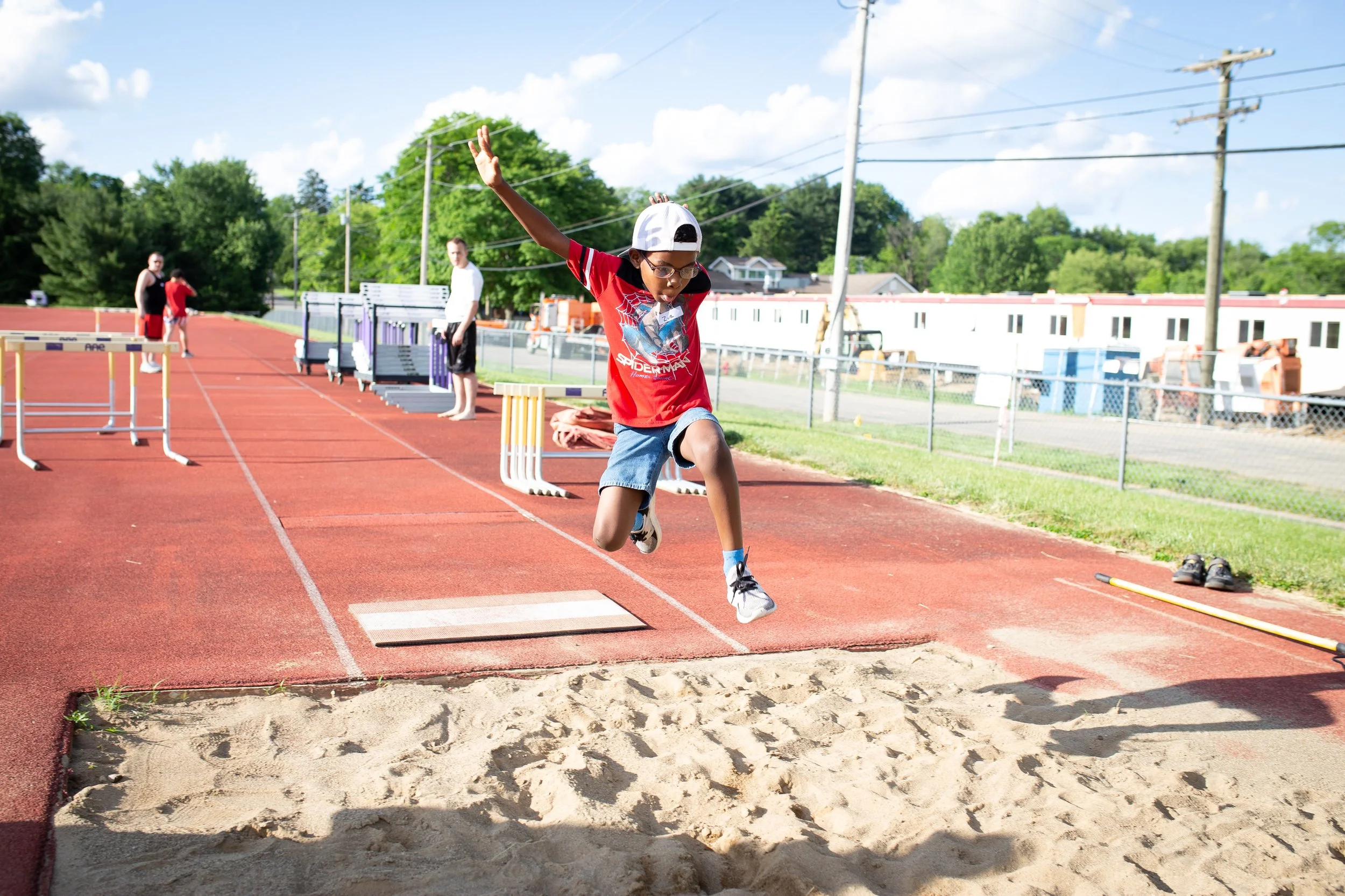 young man doing long jump for special olympics