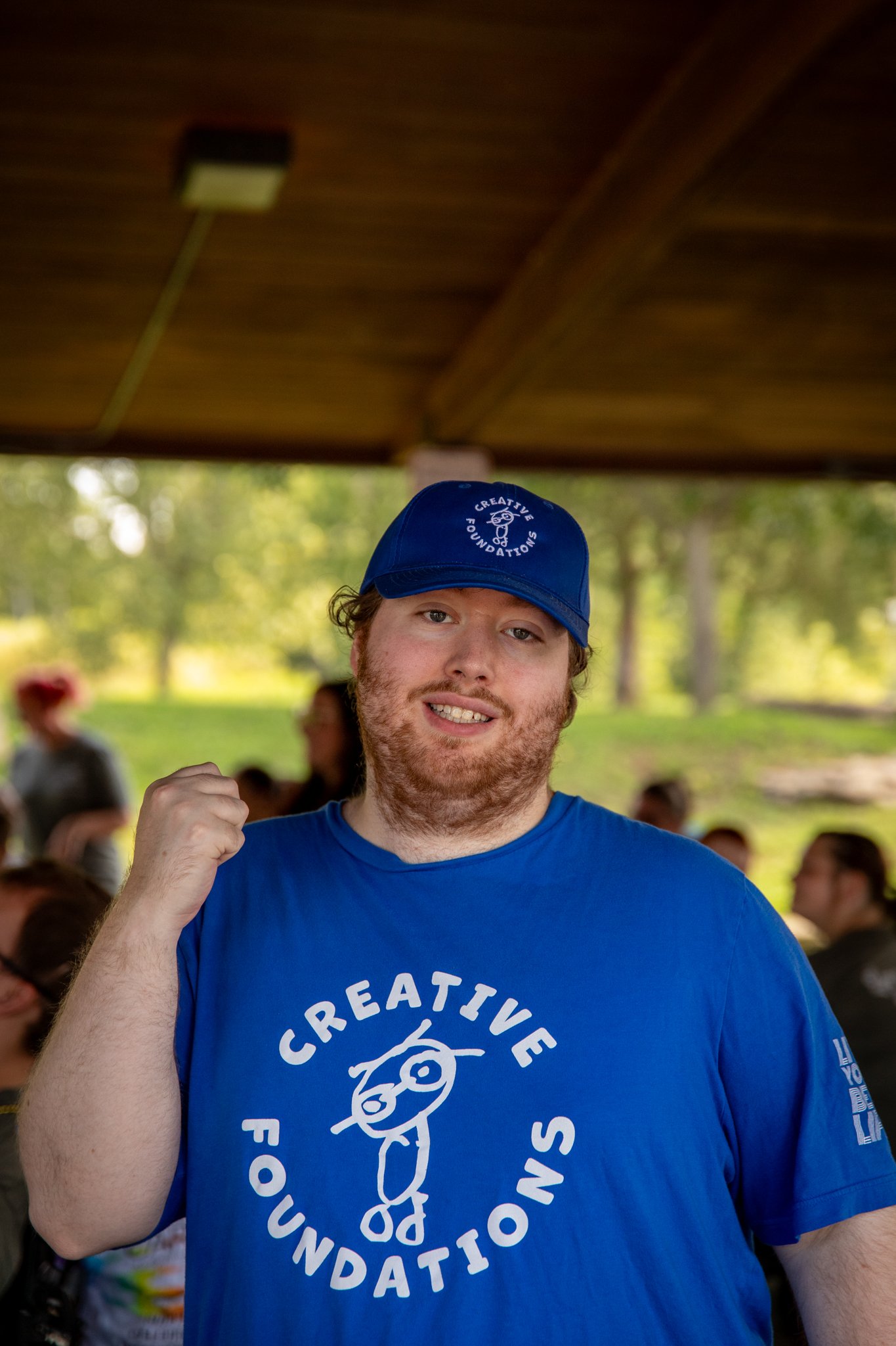 portrait of young man wearing a blue shirt and hat posing for a photo
