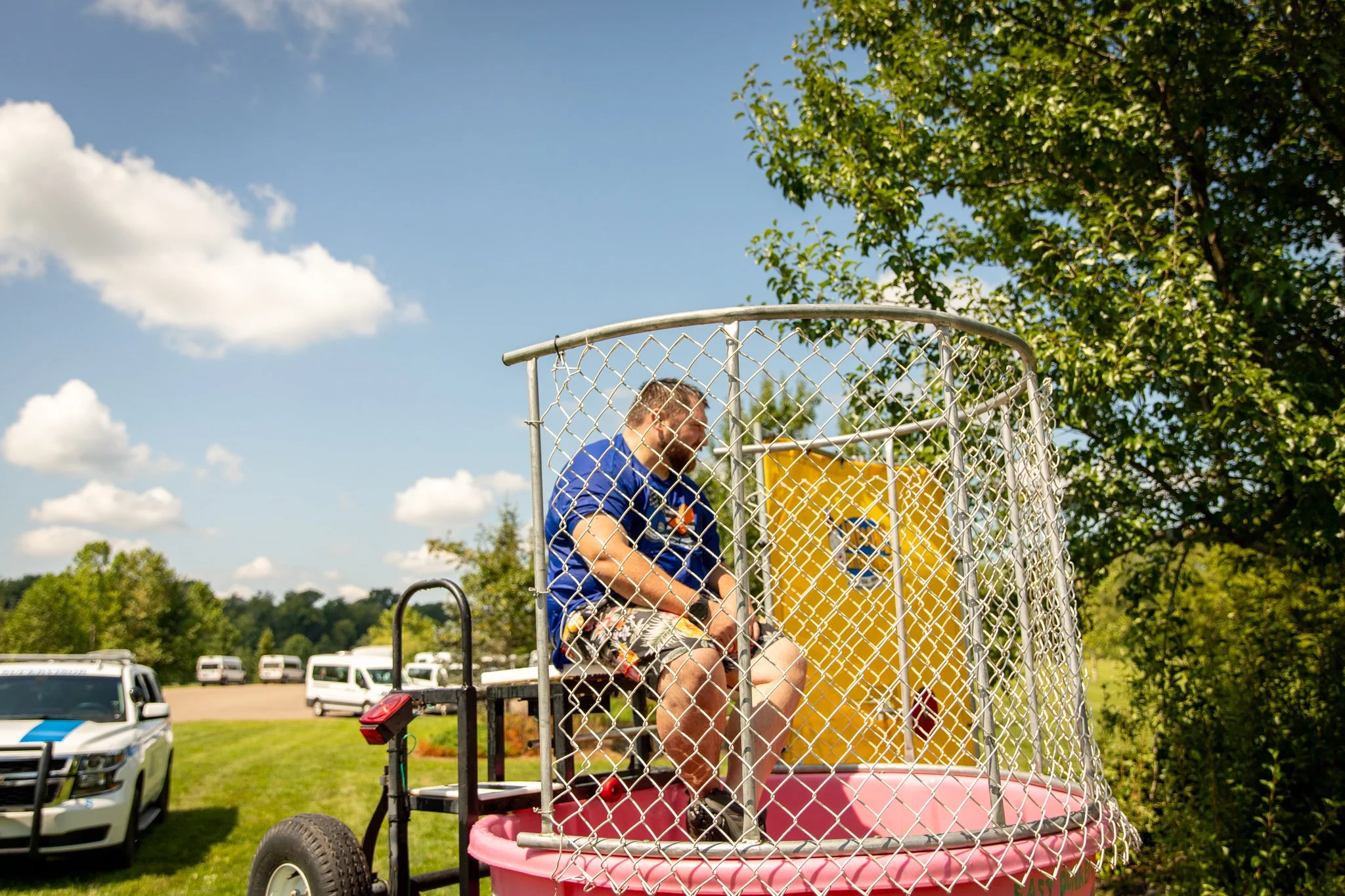 police officer wearing blue shirt in a dunk tank preparing to be dunked