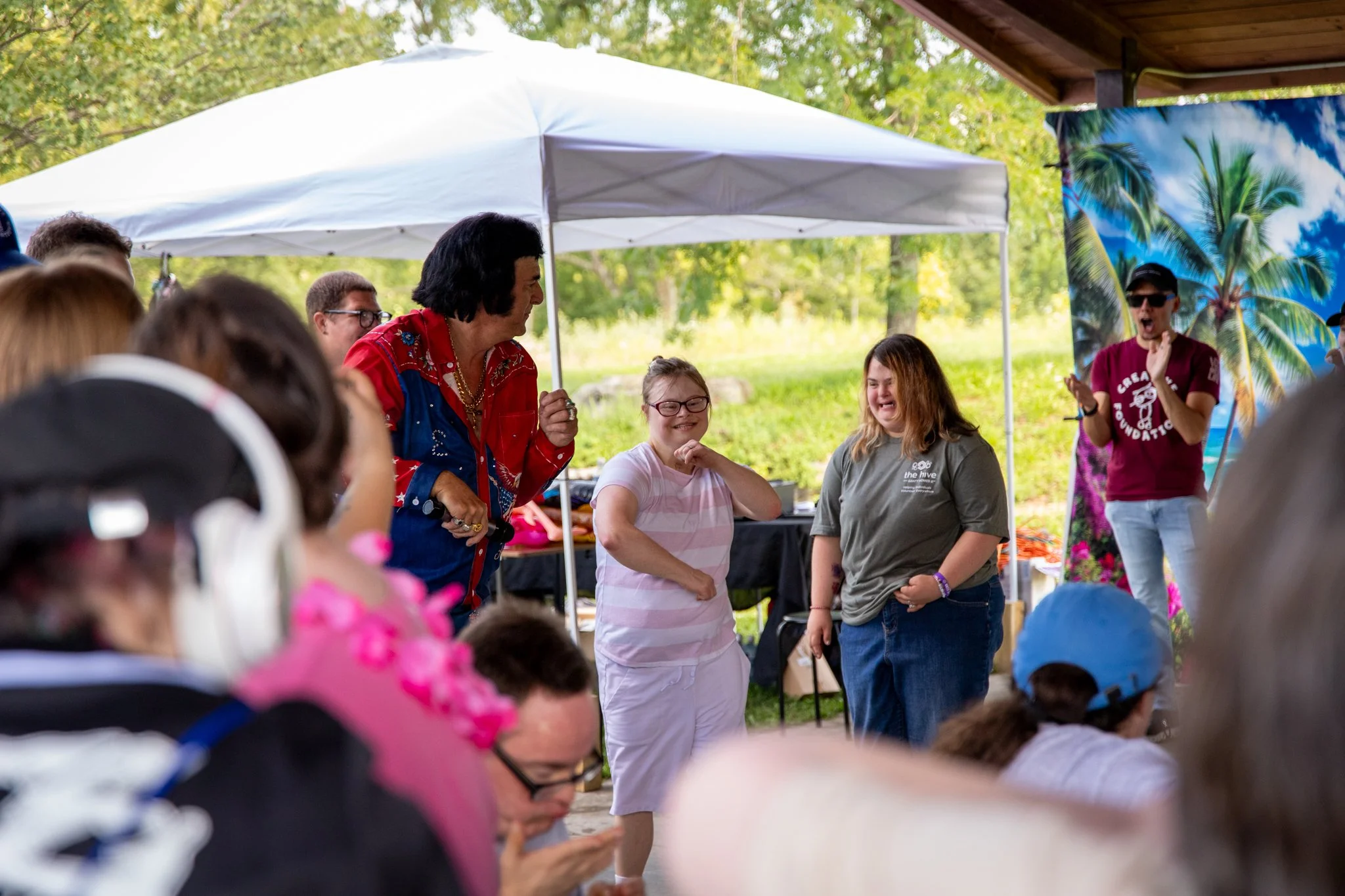 group of people standing in a row, dancing with an elvis impersonator