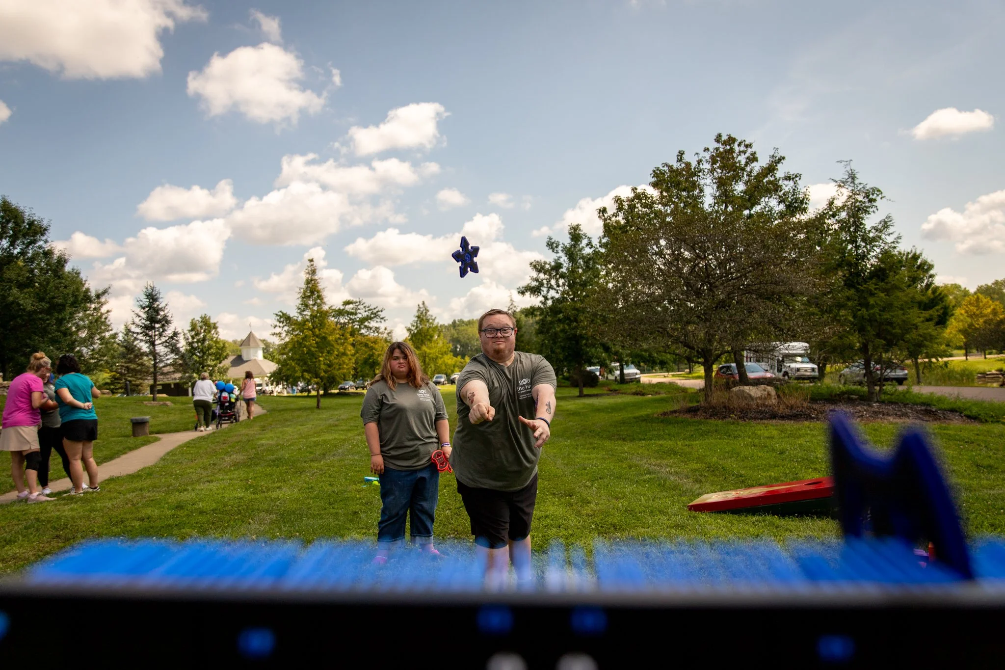 young man and woman taking turns throwing fake axe