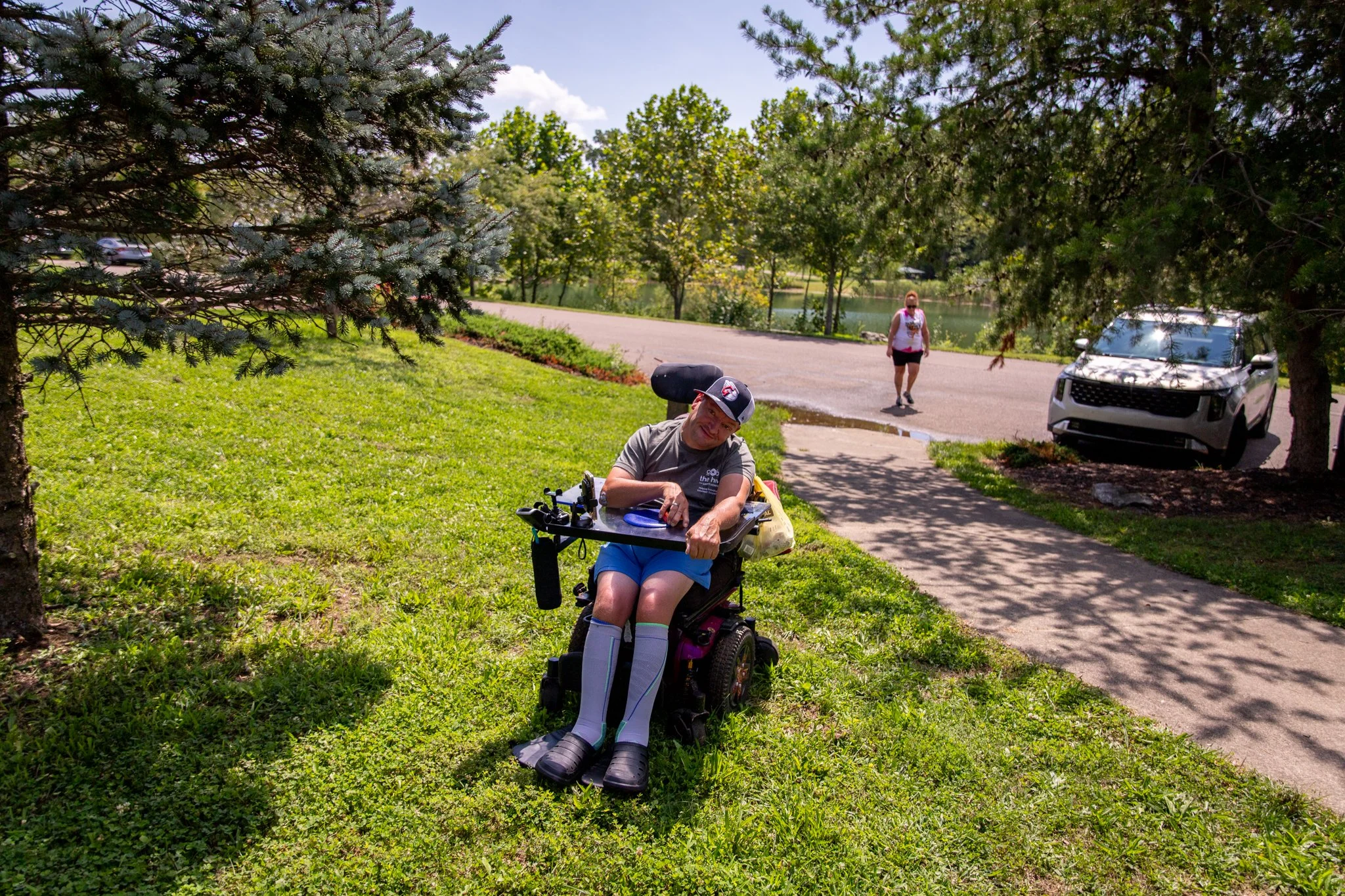 gentleman in a wheelchair sitting outside beside a tree
