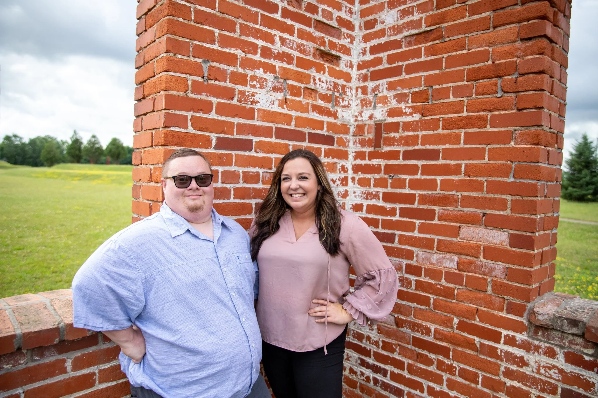 young man with down syndrome and young woman looking at camera smiling