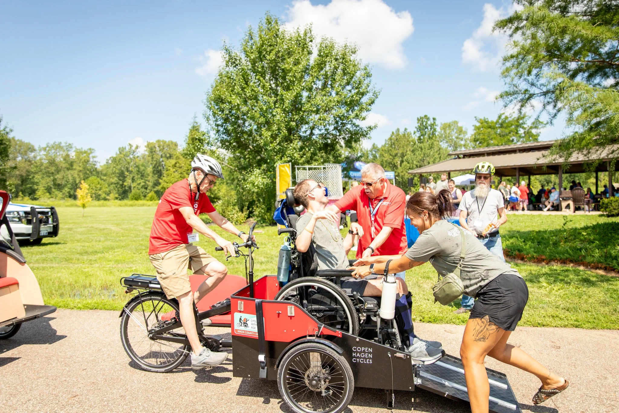 young man in wheelchair, preparing to ride on a happy spokes bike