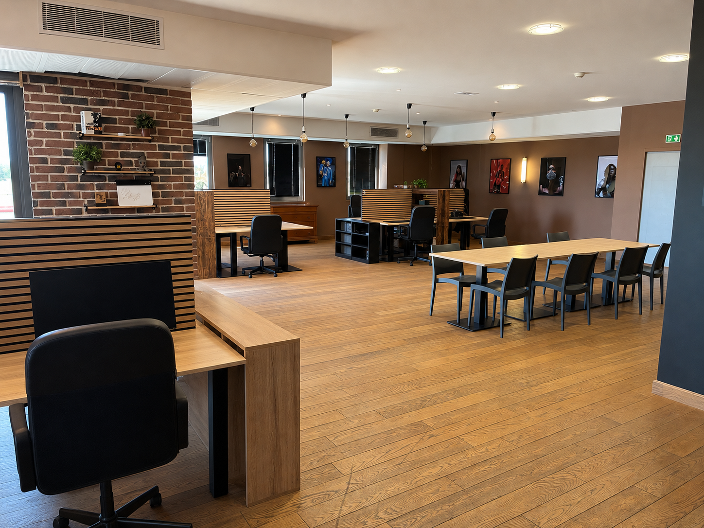 Le plateau de travail, postes séparés par des claustras en bois et mur de briques