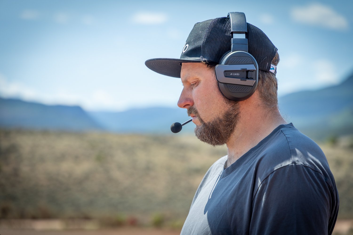 Ryan Spinks in the field wearing the Cardo Packtalk Edgephones and staring with great focus