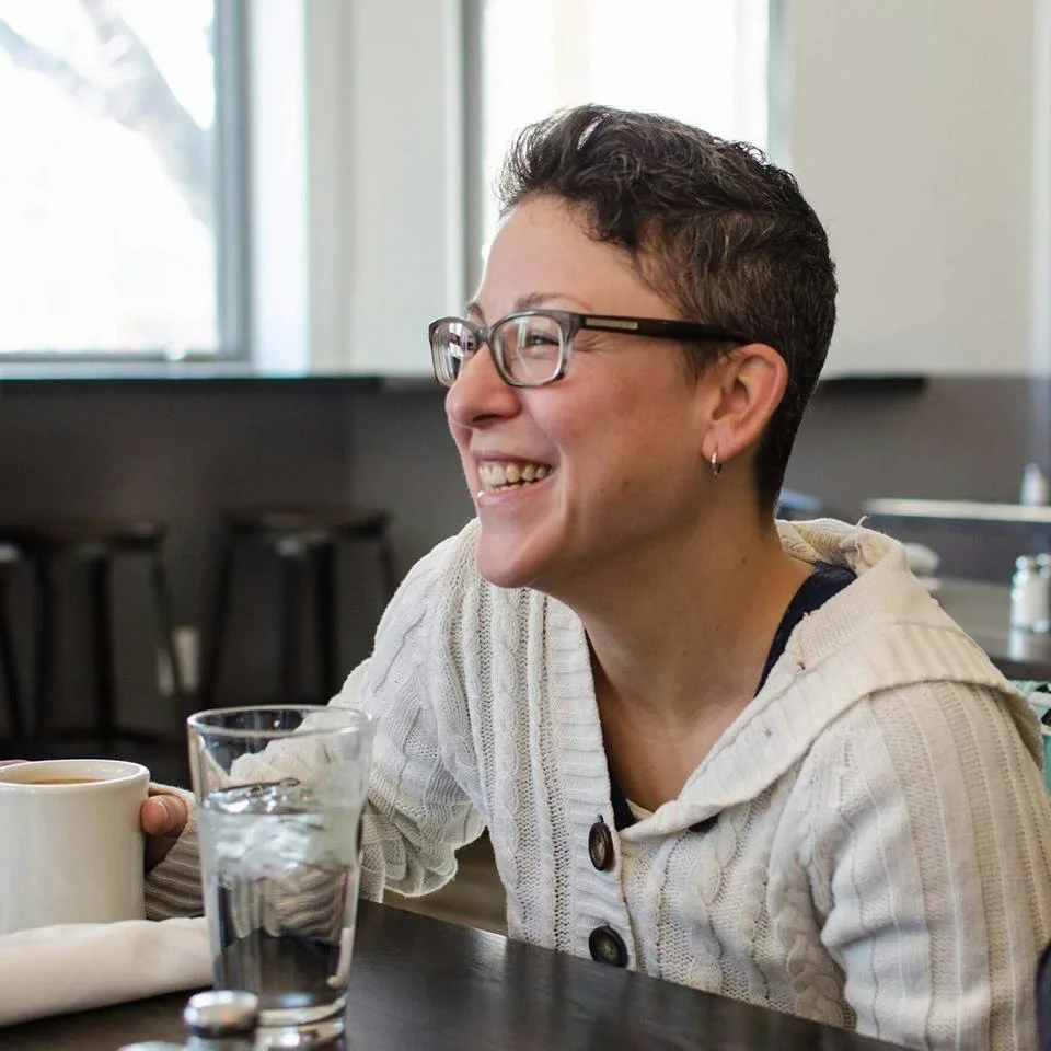 Sara Rossio, Pennsylvania Licensed Massage Therapist MSG012271 Candid photo at cafe seated at table with mug of coffee and big smile