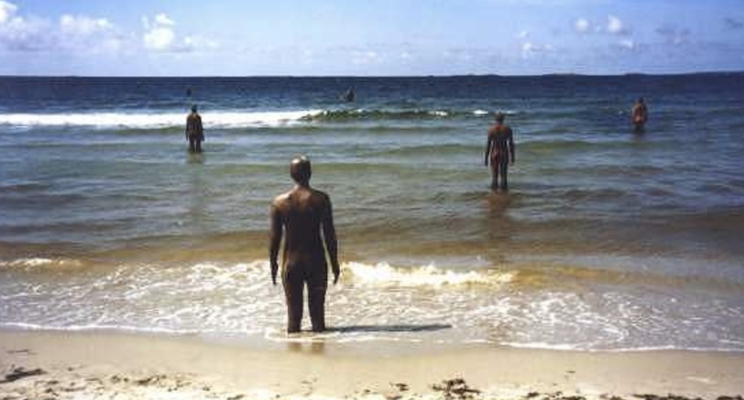 Gazing out to the horizon, some of the 100 figures that comprise Another Place are submerged by the sea at high tide.