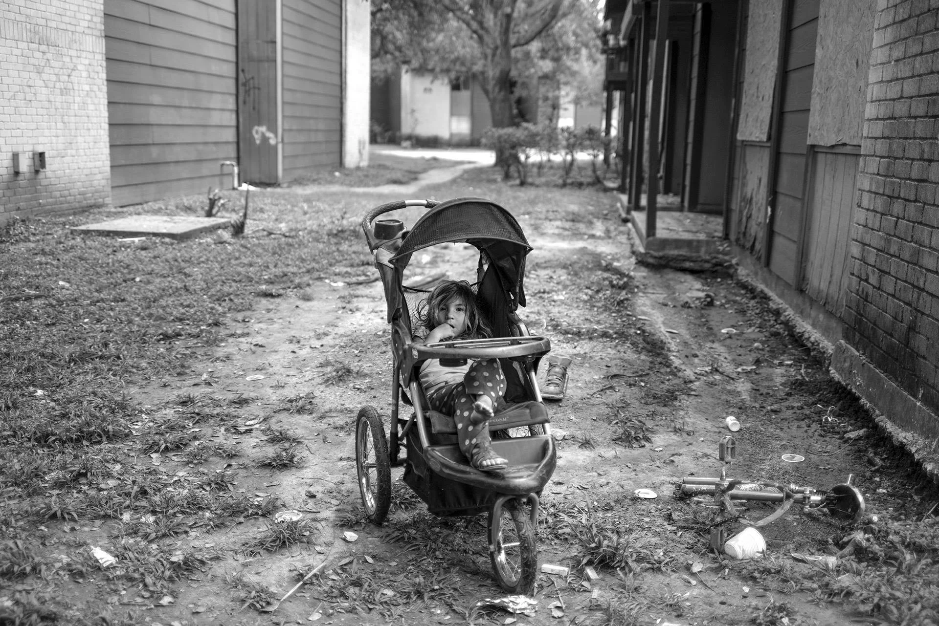September 5 Houston update: When I came out I was thinking about children such as Lucia Domingo, 3 years old and the world that we are leaving for them as our legacy. I photographed her in one of Houston's poorest neighborhoods and therefor one of the most in need and most likely to be forgotten as the recovery begins here. (I am returning there this afternoon to begin a short film on the residents there.) Lucia's father, not much more than a boy himself, still sleeps in their soggy apartment as the smell of mold and rot drift through the air. Many residents already have #asthma and this will no doubt add to their already fragile health. Some in this community are undocumented and did not want to evacuate for fear of losing what little they already have. Others were simply just cut off from the world and do not know about the risks facing them as it applies to their health, thinking that the water will just go away and doing a little bit of cleaning will take care of things. Most units on the bottom floor of this complex already have black mold on the walls (it's toxic to breathe)—many residents who had those floor level apartments are now just moving upstairs. But what happens when the mold makes its way higher and gets into the general airflow? What abut the damaged structures themselves? I was surprised to see the mold on the walls so soon after the flood, but with temperatures so hot here I guess the mold grows quicker. All I know is that the mold is there and it's potent. #Climatechange is not just an atmospheric event, it is also societal because after the storm it produces a huge strain in communities. In #Texas ' case, the clean up will cost billions and every American will have some some portion of their taxes go to help Texas get back on its feet. (And I'm all in for that and want to see Texas back to its proud self, however I have misgivings about the fact that this state's politicians do not believe their actions have a role in climate change, yet will continue making policy that adversely affects the entire planet.) The coming together here in #Houston was truly remarkable. But as I've seen countless times in countless cities in the aftermath of climate change disasters the long term extremely difficult part of compensation begins and the poorer neighborhoods will, as always be the ones overlooked, another way how the climate bleeds into the social. On another related, but separate note: As the 45th president of the United States considers to destroy #DACA , a program that 800,000 vitally depend on to keep them engaged and contributing to this country, its dissolution threatens to further isolate immigrants into the corners of society. The result is that girls like Lucia will not have schooling or the ability to contribute to society, but become a drain on it because she has so few options. #healing , #climatechange, #climatechangeisreal , #globalwarming