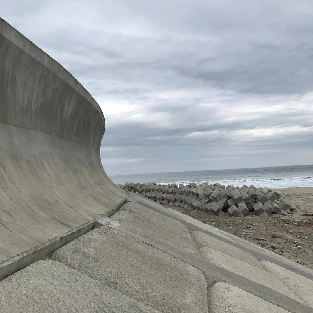 October 10, 2017 #Fukushima and #Miyagi update: One of the most profound environmental landscape changes I've ever seen is the wall that's been built between the sea and land in northern #Japan . The wall rises about 10 meters (30 feet) and extends for hundreds of kilometers or roughly the equivalent of the distance between Washington DC and Providence Rhode Island which is the swath of land that the tsunami struck. Sadly the wall shuts off the sea from view and produces a walled in existence severing the connection to the sea that's existed in #Japanese culture since the beginning of its existence. The inspiration of those magnificent wood block prints and poems now obscured behind a cold flat wall. What the wall is also blocking is centuries of knowledge that's been passed down: farmers used to be able to read the tides because they'd flow forth from the ocean into land letting them know about tsunamis and other events-blocked off we are apart from it and I'd also apart forms an essential part of our collective human existence. I wonder if children born here now will even know what lies behind the wall if their parents don't take them up the high steps that Overlook the watery horizon? On the part of the authorities, walling it off is an act of massive denial: sea levels are still rising and the sea is still there, it's not going away. By building this concrete monolith we are turning our back on the wonder and love of something that has sustained us since the beginning and replacing it with a false sense of security. Ultimately we have only one choice with the sea: understand it and move with it or await it to breach our shortsighted strategies that only benefit the producers of concrete.