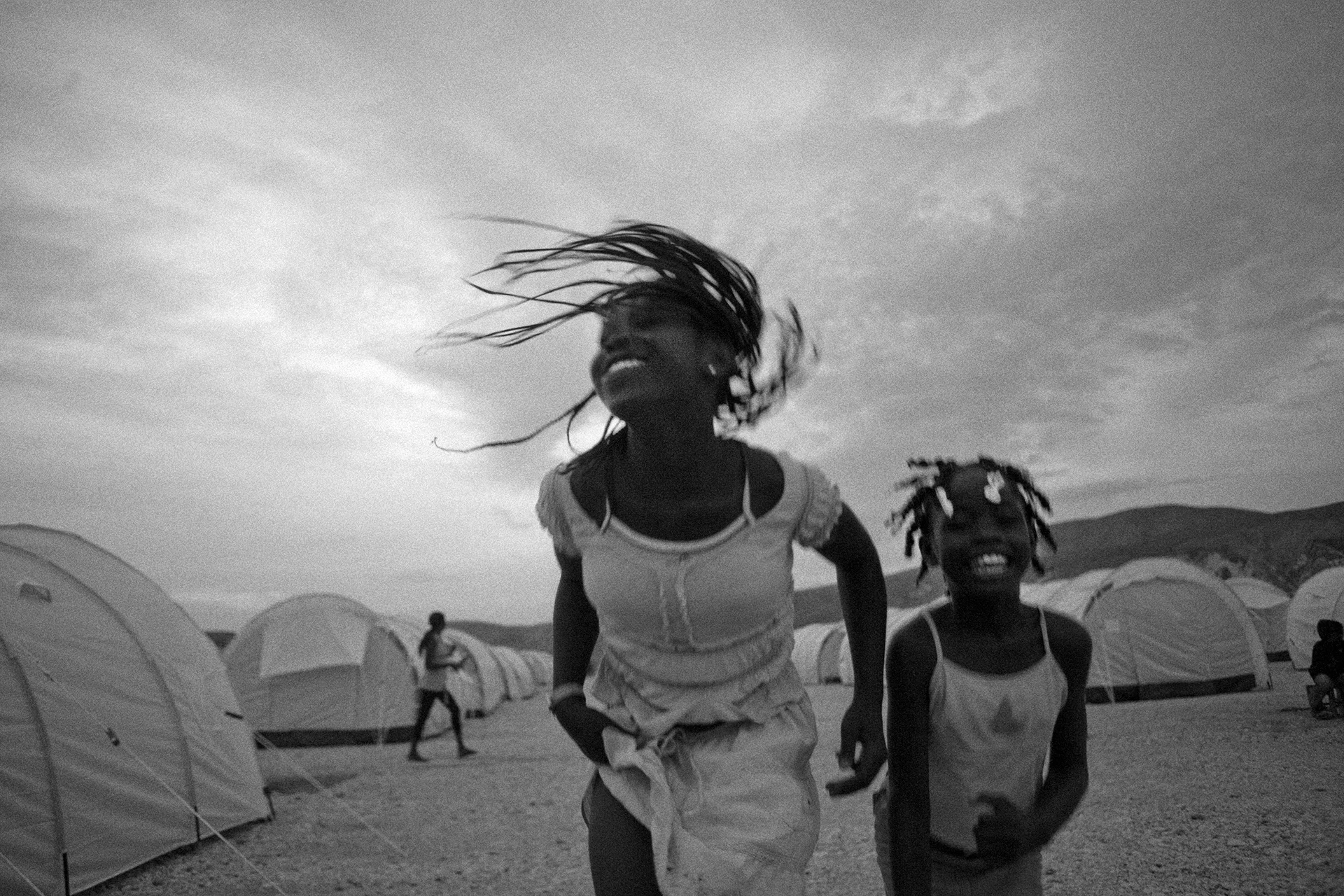 January 12, 2018 Over the next 7 days I will be posting photos I took in #Haiti to commemorate the victims and strong hearted survivors of the #2010earthquake —and to address the deplorable comments made by the United States president. I will show Haiti and its people as a place very much in contrast to his and much of the media’s characterization of it. In 2010 when I worked there extensively for the New York Times, BBC & MSF I saw a lot of hardship, but I also saw much #beauty and so many strong and kind people whom I am grateful to have in my life. One of the reasons that countries such as Haiti can be perceived as being a "shithole" is due to the imagery that comes from them. I believe that media outlets are complicit in furthering the stereotypes that then further add to misguided perceptions of the country. I believe that an entirely different imagery is needed from Haiti and #Africa that shows these places in their #complexity #strength , #intelligence , #humanity and #compassion . Most of the photos that I will be sharing over the next week have been never been published as they did not fit a particular narrative that editors were seeking at the time. This photo was taken in one of the most austere IDP camps in the world, the Corail-Cesselesse camp, however, in this moment, these girl's spirits were as bright as the life there was difficult. Everyday they struggled to achieve a better life and in that struggle I felt it was important to show them at their brightest. Corail-Cesselesse was situated at the base of a mountain that flooded when it rained and baked when it was hot. Far from descending into incivility I found that Haitians across the board reacted to this disaster with civility and elegance—they did not let the hard situation get the best of them but tried to make things better even as they were up against tremendous odds. When things were ugly, more often than not, I found them to be elegant, when world leaders took the lowest shots at them they proudly held their heads high. And they still do.
