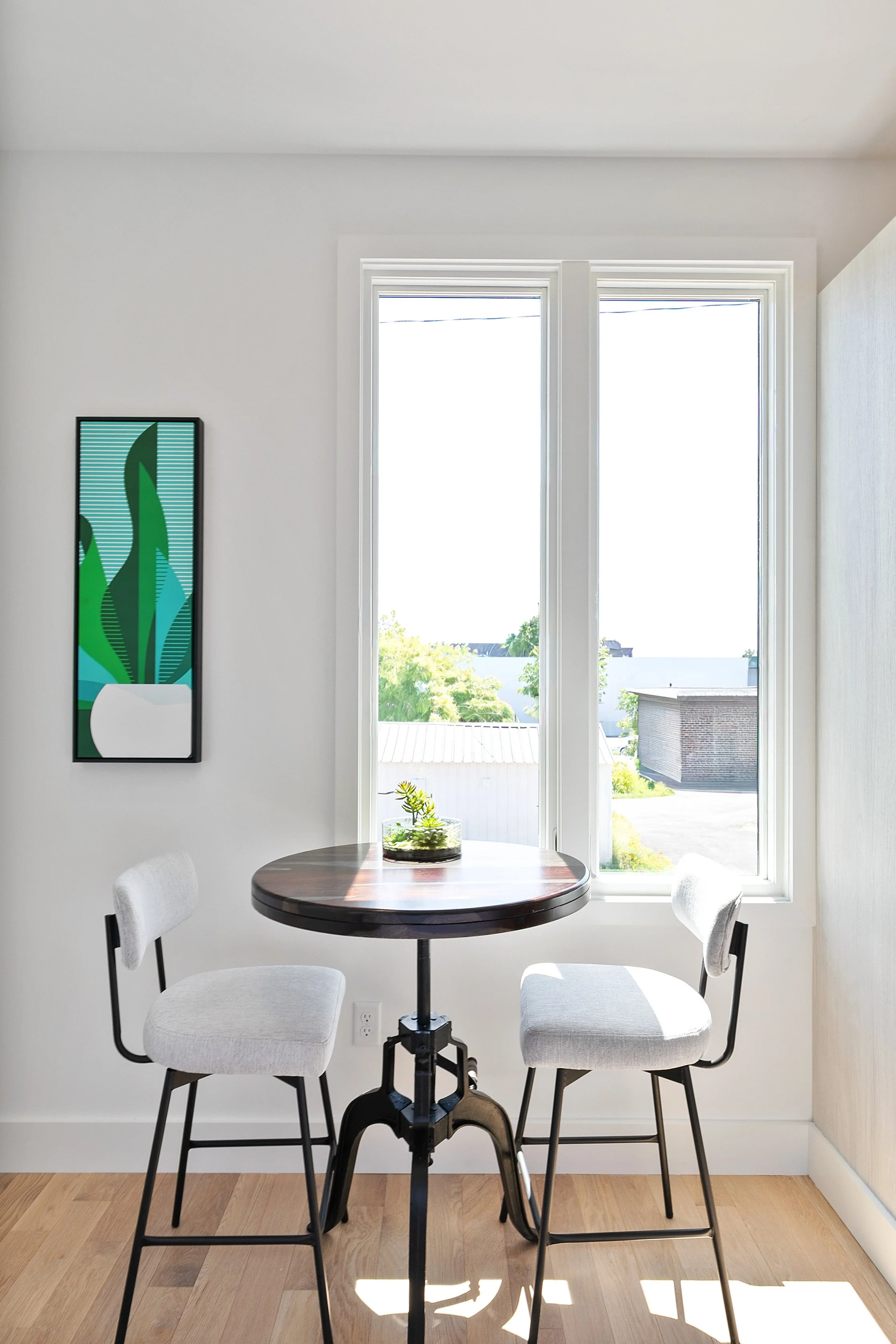 Sunny kitchen breakfast nook with round table and gray upholstered chairs after home staging at 2 N Brunswick St Richmond VA