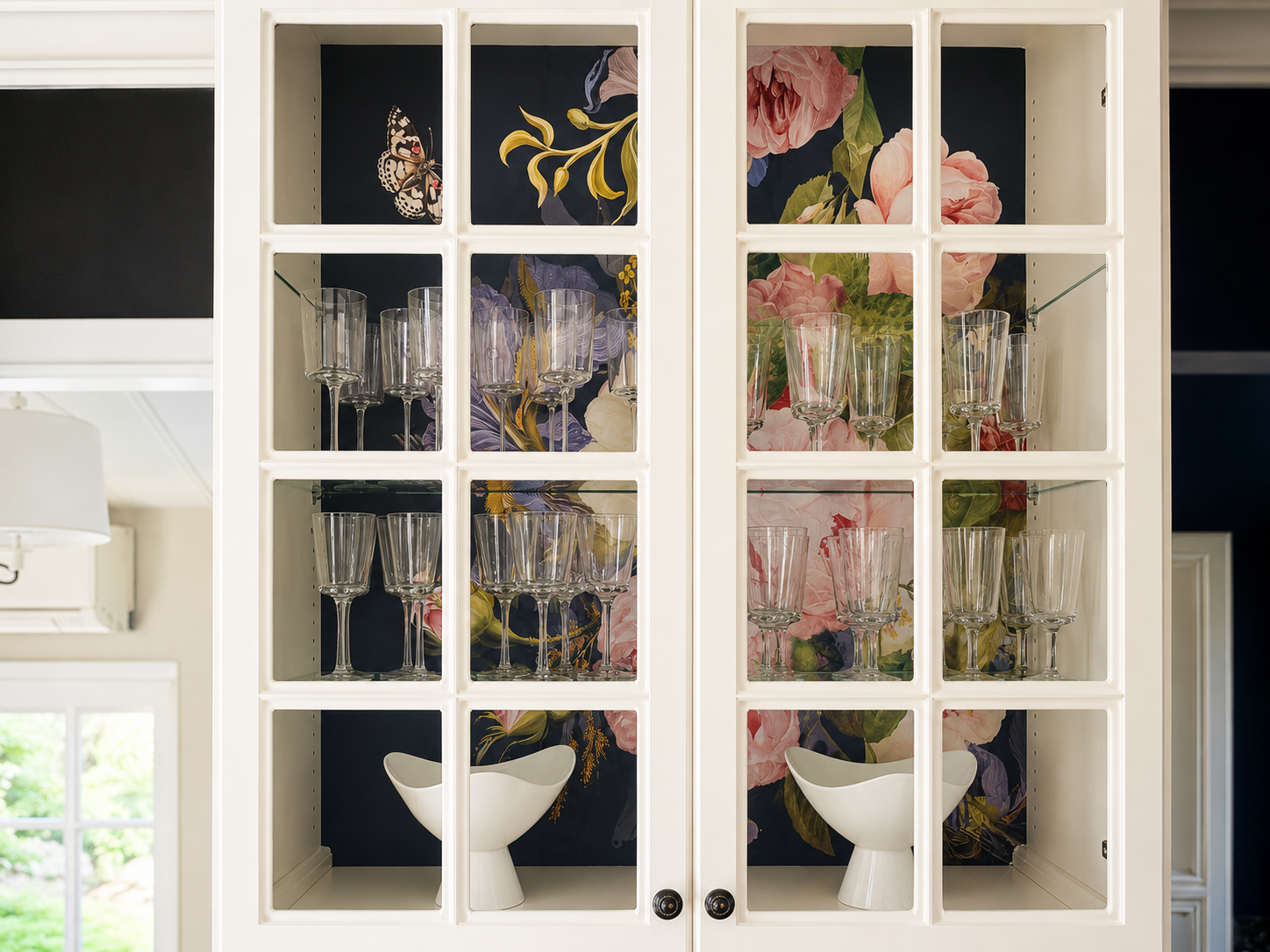 Styled glass-front kitchen cabinets with floral backing, decorative glassware, and luxury interior design details in a Richmond, VA home.