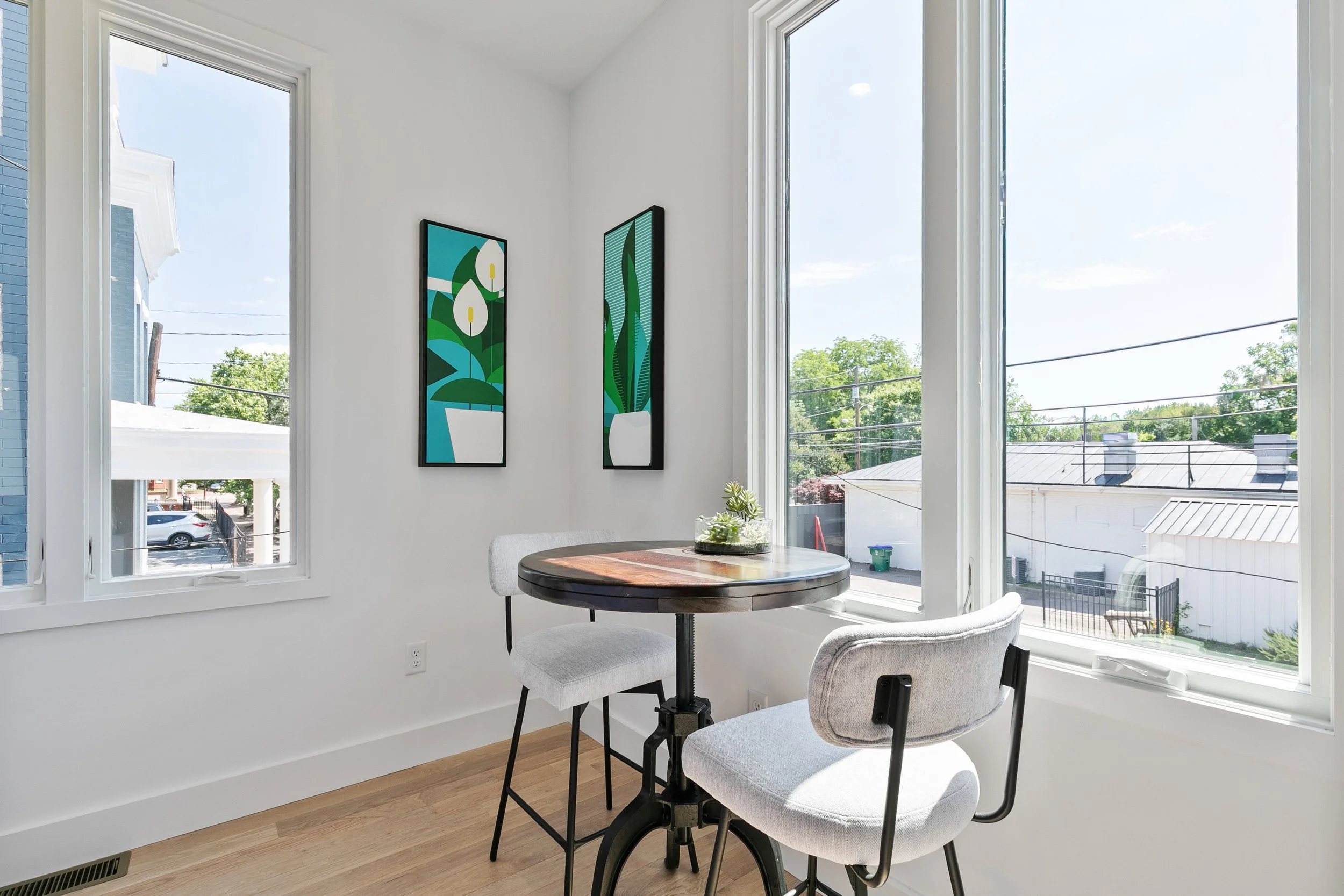 Bright breakfast nook with round table, gray chairs, and large windows at 2 N Brunswick St staged home Richmond VA