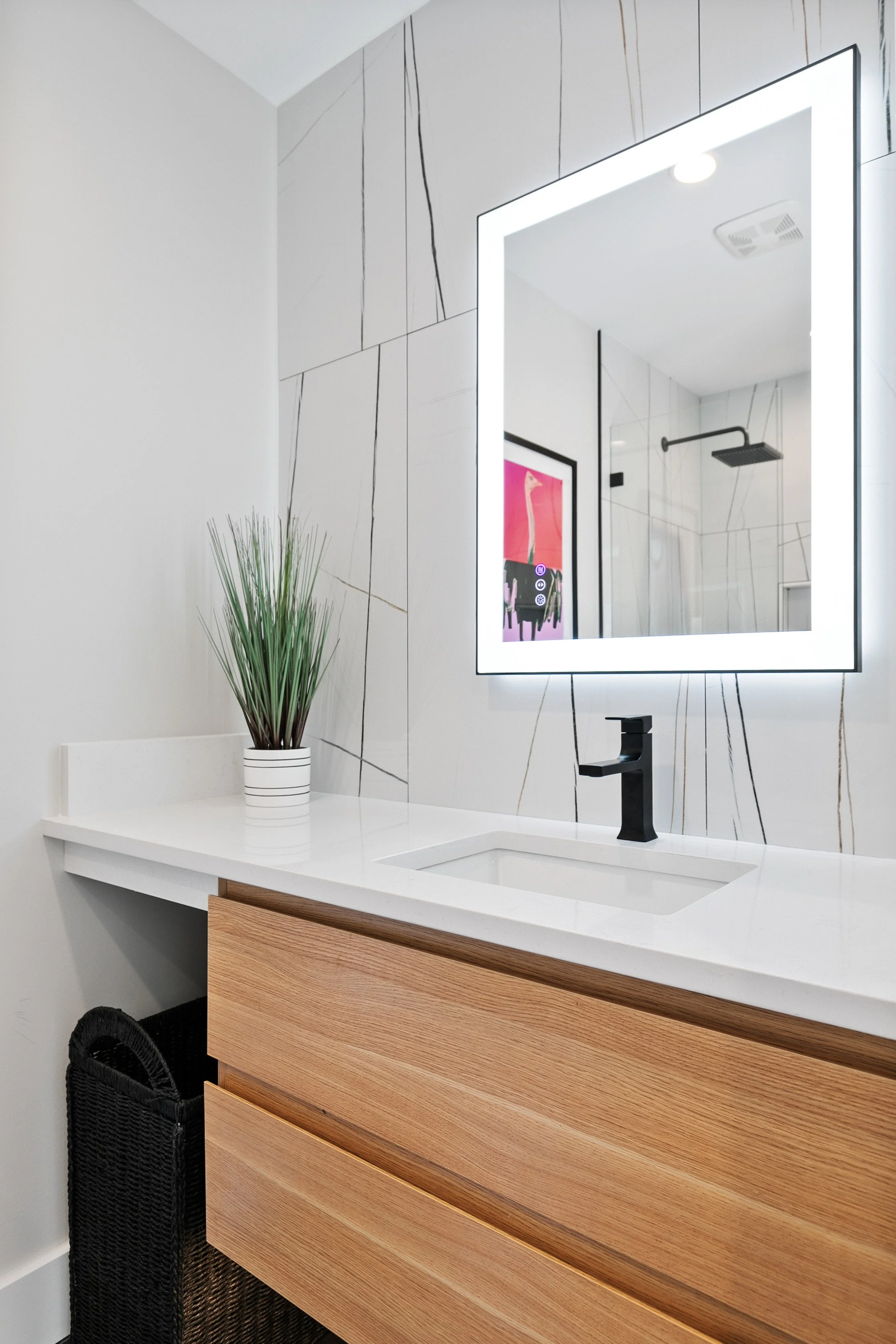 Stylish bathroom vanity staging featuring wood cabinetry, white countertop, and backlit mirror at 2 N Brunswick St Richmond VA