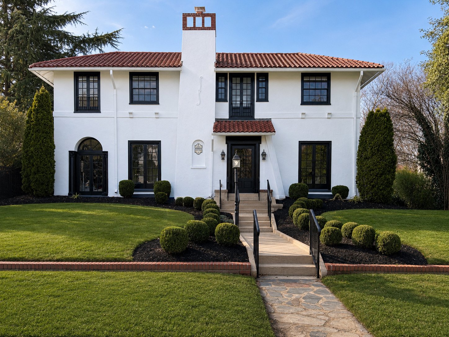 Luxury Mediterranean-style home exterior in Richmond, VA featuring white stucco, black-framed windows, terracotta roof, manicured landscaping, and enhanced curb appeal for premium real estate marketing.