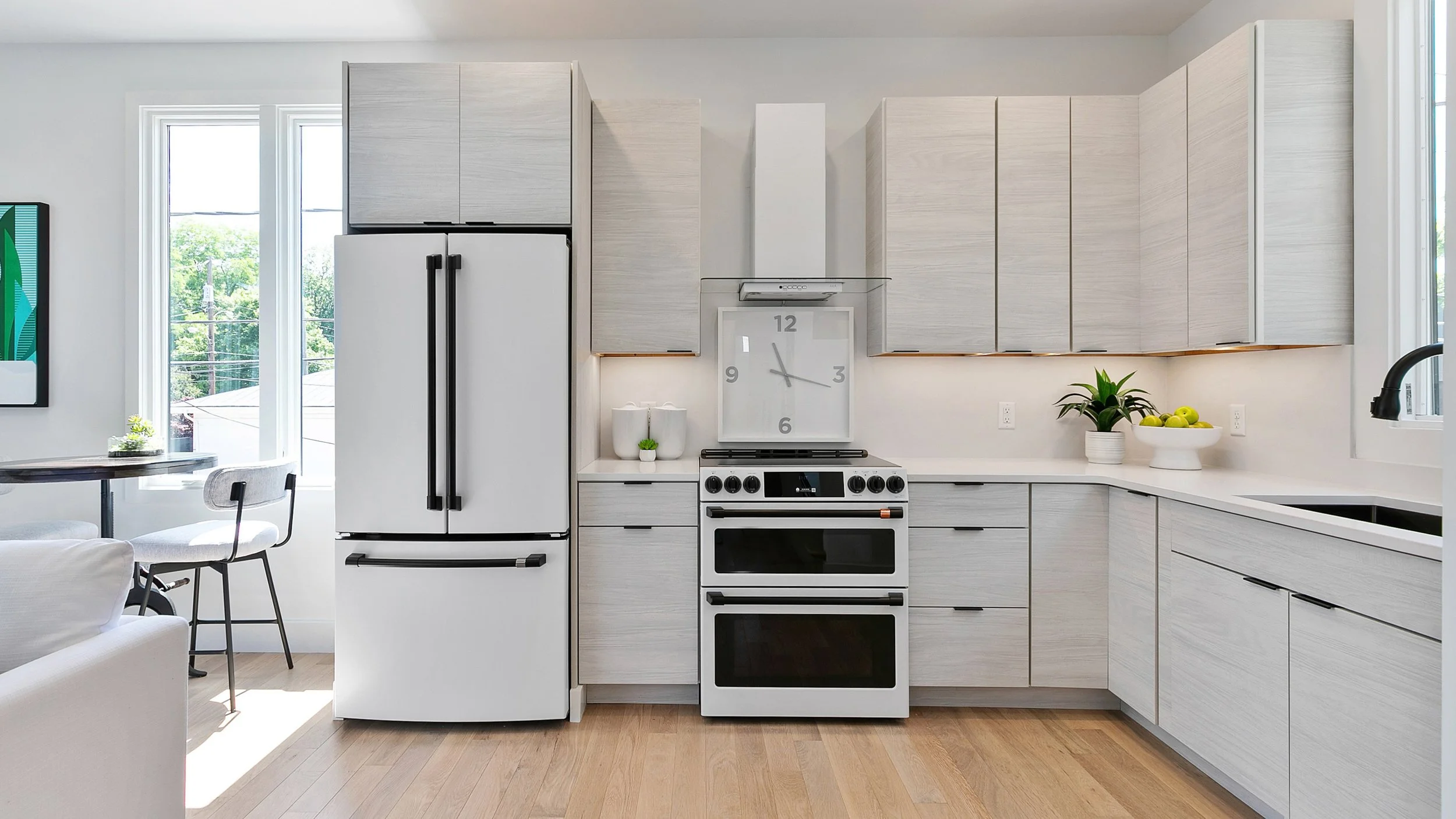 Modern light kitchen with white cabinetry, stainless steel appliances, and open layout after staging at 2 N Brunswick St Richmond VA