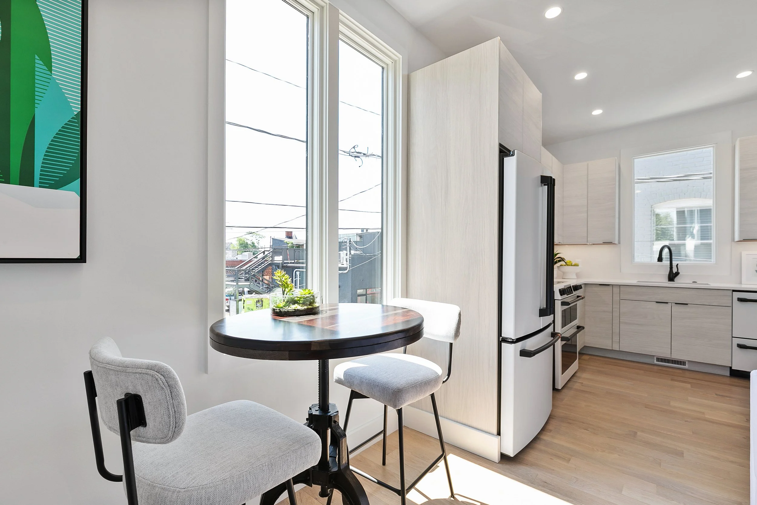 Bright breakfast nook with round table, gray chairs, and large windows at 2 N Brunswick St staged home Richmond VA