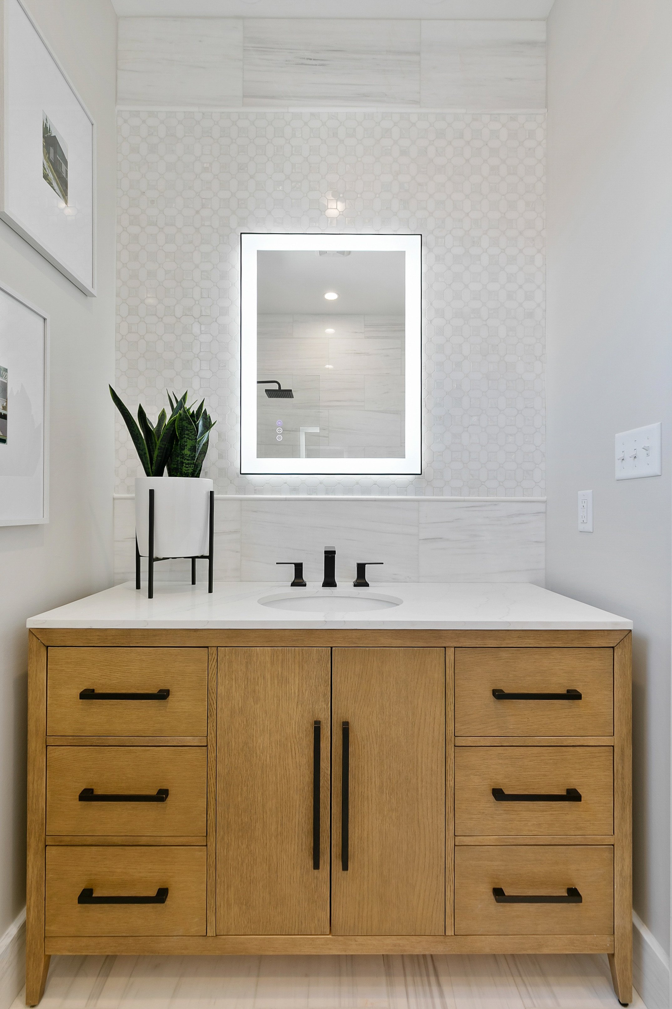 Elegant bathroom vanity with wood cabinet, white marble countertop, and large LED mirror staged at 2 N Brunswick St Richmond VA by Jsquared RVA