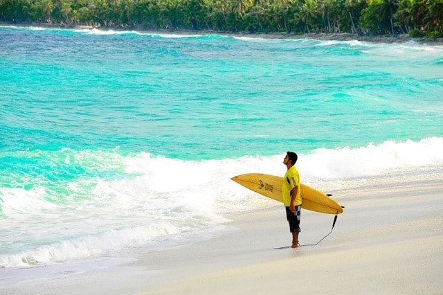 surfer standing at water's edge apprehensive