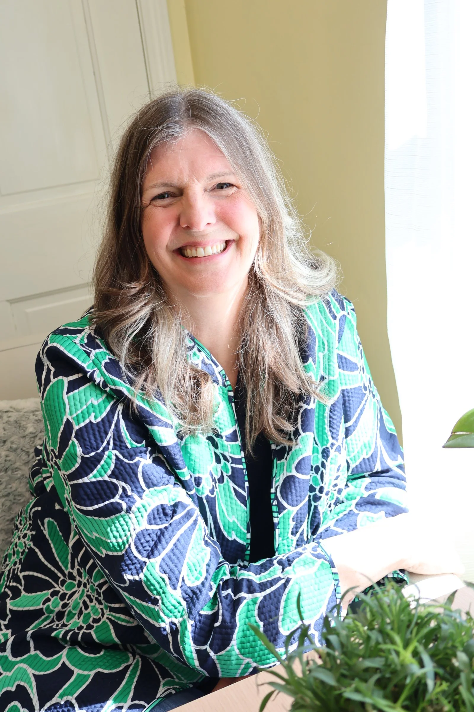 Lynette sitting by a window smiling
