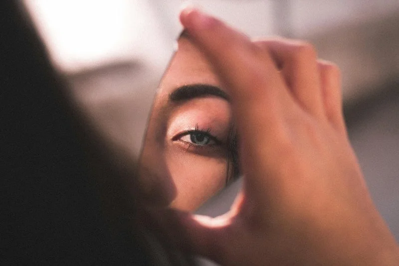A broken mirror with a person's reflection