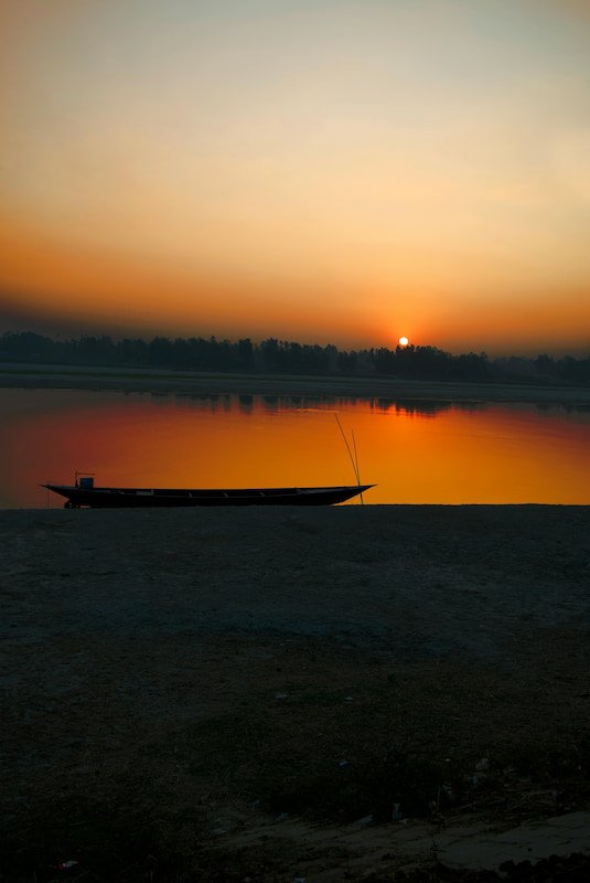 a boat at sunset on a calm lake
